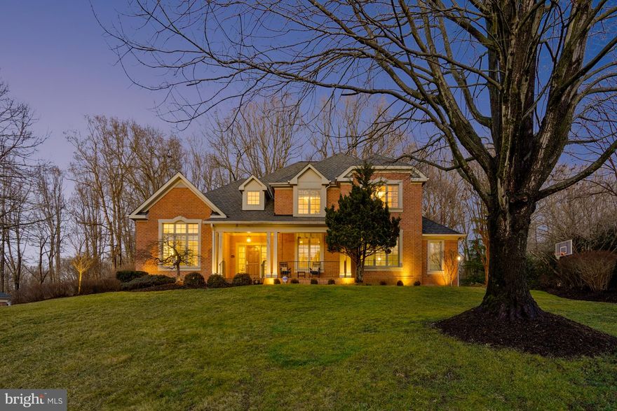 Set on a beautifully landscaped acre surrounded by mature trees, this turnkey, brick colonial offers ultimate privacy and an idyllic outdoor setting. Located in a quiet neighborhood with easy access to Tysons, the home blends timeless style with modern functionality. A welcoming front porch with southwest exposure offers a perfect spot to enjoy sunsets and morning coffee, adding to the charm of this beautiful property. 
Inside, the layout is designed for both everyday living and entertaining, featuring six spacious bedrooms and an inviting flow throughout. The main level boasts a grand 18-foot foyer that sets a striking tone as you enter. The elegant living and dining rooms boast floor to ceiling windows and beautifully crafted crown molding. The bright white kitchen features granite countertops and an island overlooking the family room, which is showcased by coffered ceilings. Upstairs, the primary suite serves as a private retreat, with three additional bedrooms offering comfort and charm.
The expansive walk-out lower level is perfect for recreation, featuring a wood-burning fireplace, generous spaces, and two bedrooms connected by a full bath—ideal for multi-generational living or an in-law suite.

Step outside to a private backyard oasis with a fire pit, hot tub, and abundant space for relaxation and entertainment, all framed by lush greenery. With a combination of thoughtfully designed interiors and an exceptional outdoor retreat, this home provides the perfect balance of comfort and style. Public water and sewer add to the convenience and appeal of this remarkable property.
