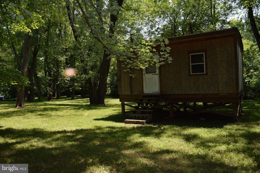 Enjoy your own family campground and create memories to last a life time! Approx 875' of Potomac River front property with over 11 Acres. Park like setting,16X24 elevated structure with three divided rooms, wood stove hook up. Outhouse, fire pit, cleared path to river. Items in structure to convey. This property is gated and private, do not enter without the company of an agent with prior approval