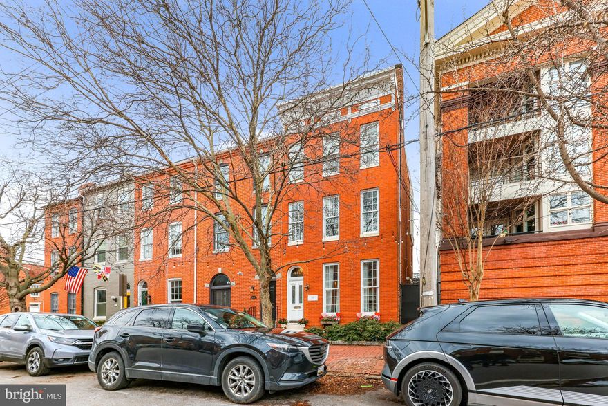 Welcome to the opportunity to own a beautifully preserved 19th-century rowhome in Federal Hill. Built in the 1800s, this stunning residence offers 5 bedrooms and 3.5 baths, blending historic character with thoughtfully updated interiors. While this historic rowhouse offers plenty of charm with its original architectural details like inlaid hardwood floors and ornately carved marble mantles, it also provides modern conveniences such as sizable closets and updated systems for efficiency throughout the 3,000 square foot home. This listing is ideal for families seeking a close-knit community in Baltimore City.

The first floor offers 9 foot ceilings in the front vestibule and living room, which has a working gas fireplace for enjoying cozy winter nights and a convenient half bath/powder room and a coat closet. The rowhouse flows seamlessly into the moody dining room with fireplace and wainscoting and a bright kitchen featuring white cabinets, white quartz countertops, stainless steel appliances, and a bay window overlooking the backyard with its all-brick patio. The first floor is ideal for hosting gatherings like birthday parties and holidays, and it has been a hub for neighborhood families in recent years.

Upstairs, the second floor offers three generous bedrooms. The front bedroom has a working gas fireplace with brick surround and ample built-in cabinetry for books, media, or toys. The hallway has a full bathroom with tub. The back half of the second floor has two shotgun-style bedrooms linked by a beautiful updated bathroom with a new shower featuring tiling and a bench. This setup is ideal for small children.

The third floor hosts the primary bedroom with its soaring ceilings, views of the treetops, two skylights, and a Victorian-era coal-burning stove (decoration-only). The hallway has an updated full bathroom. The final bedroom features three closets, including a large walk-in closet. The current owners use this final bedroom as their office, utilizing the entire third floor as a primary suite. Hallway stairs lead up to the rooftop deck offering views of the surrounding neighborhood and nearby stadiums.

This desirable location offers close proximity to Cross Street Market and the Entertainment District with restaurants, taverns, and shopping. The federal-style home is two blocks from the Inner Harbor, its views of the water, and nearby attractions like the Science Center and Aquarium that are within walking distance for families. Enjoy long walks around the neighborhood in the spring and fall months, and take the Harbor Connector to Fells Point or Harbor East to enjoy a movie or meal on the water in the summer. The neighborhood is a hub of activity for Ravens fans and Orioles fans on game days. The 800 block of William Street is known for its holiday festivities, like the Fourth of July parade.