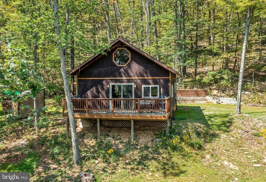This cozy 2 bedroom cabin sits nestled in the heart of Hampshire County. You will have just over 10 acres of wooded land to explore. Your large deck features great views where you can enjoy countless sunrises and sunsets. There is so much potential here. It's perfect for a primary residence for someone looking for privacy. You could use it as second home when looking to get away from the hustle and bustle of daily life. You might even be able to use is for an airbnb.  No matter your needs this property can work for you! Call for more information today.