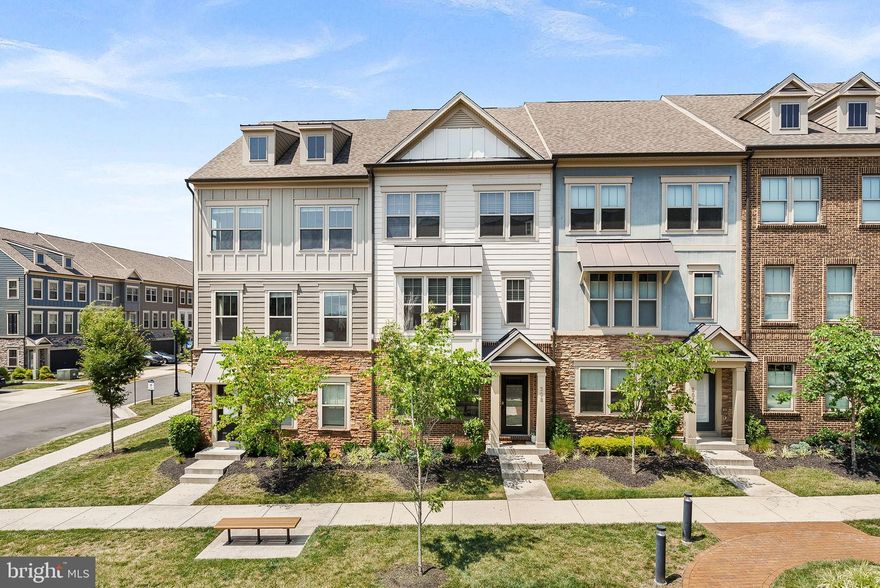 Welcome to Tuscarora Village, where style meets convenience! This four-level "Jenkins" model townhome offers 3 bedrooms, 2.5 baths, and over 2,350 square feet of living space. Built in 2020 and loaded with upgrades, this home shows better than a model. The entry level features a welcoming foyer, coat closet, and direct access to your oversized two-car rear-load garage. Upstairs, the main level is an entertainer’s dream with luxury vinyl plank flooring throughout, gourmet kitchen boasting a 9-foot quartz island, stainless steel appliances, range hood, farmhouse sink, and soft-close cabinetry. The dining area includes a custom built-in cocktail bar with wine fridge  and opens to a low-maintenance Trex deck. Spacious family room showcases an added bump-out with a modern fireplace surroinded by craftsman shelving, and large windows that flood the space with natural light. Third level hosts a luxurious primary suite with recessed lighting, walk-in closet, and a spa-like bath featuring a dual quartz vanity, frameless glass shower with bench, and floor-to-ceiling tile. Two additional bedrooms share a full bath, while the laundry room is conveniently located on the same level. The top floor offers endless flexibility - perfect for a rec room, office, or lounge and opens to a private rooftop terrace, ideal for relaxing or entertaining. Community amenities include a pool, clubhouse, and playground while direct access to the W&OD Trail makes this a dream location for bikers, runners, and dog-walkers. Just minutes from downtown Leesburg, the Villages at Leesburg, One Loudoun, and commuter routes, this home delivers the perfect blend of modern living and everyday convenience!