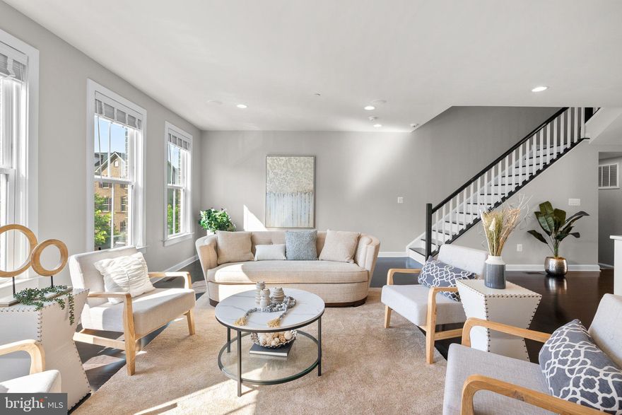 This spacious townhome is atypical in that its 28' width feels more like a detached home. The low maintenance exterior is designed with classic and timeless features, including tasteful architectural details, pristine landscaping, and energy-efficient features to help reduce your carbon footprint and save on utility bills.

As you enter the home, you are greeted with luxury interior appointments that seamlessly blend modern sophistication with comfort and convenience. The main level office could easily double as the media room, playroom or possibly the 4th bedroom with en-suite bath. There is access to the 2 car garage just beyond the entry hall with wait station.

Ascend the 5" ebony hardwood stair to the second living level. There you find a designer kitchen that boasts Profile appliances, custom cabinetry with crown trim, 10' island with waterfall quartz and additional premium finishes, making it a perfect space for culinary pursuits and entertaining guests. The dining room easily seats 8 or more and opens to the covered grand balcony.

The upper level is reserved featuring bedrooms that are generously sized, providing ample space for relaxation and restful nights. Each bathroom is equally impressive, with sumptuous details such as marble countertops and ample storage space. The spacious primary suite pampers you with a luxurious en-suite bathroom featuring dual vanities, a soaking tub, and a separate shower. The two other bedrooms share a full bathroom, and there is also a convenient laundry room on this level.

This townhome is thoughtfully designed with high ceilings, hardwood floors, recessed lighting and energy-efficient features that promote sustainability and help keep energy costs low. From insulated windows and doors to high-efficiency heating and cooling systems, you can enjoy luxurious living while making a positive impact on the environment.   The location of this townhome is also ideal, as it is conveniently located close to shopping, dining, and public transportation.