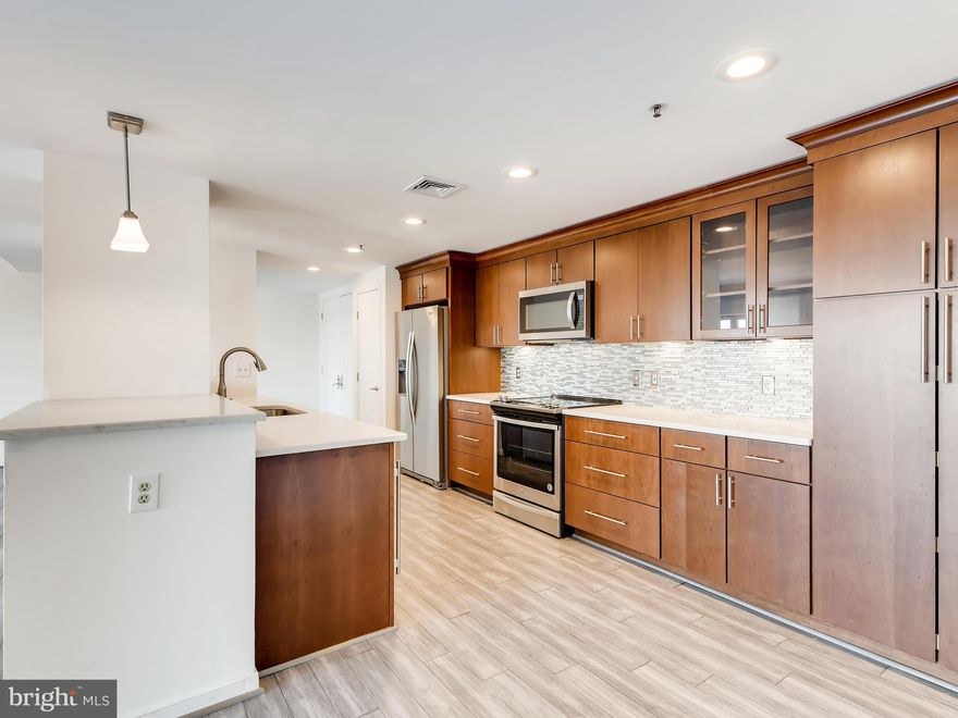Gorgeously renovated, light-filled, two-bedroom unit in full-service, secure, elevator building offering a 24-hour front desk, on-site management, indoor pool, waterside sundeck with grills, community library, gym, and resident lounge.  The elegant double entry doors open to a wide foyer leading to a spacious living/dining combo space with huge oversized windows and a private city view balcony.   The split bedroom design with sleeping spaces on either side of the unit provides ultimate privacy.    Contemporary flooring throughout.  Kitchen equipped with stainless appliances and beautiful cabinetry topped with granite counters.   Bathrooms updated with granite counters, new vanities and modern light fixtures.  Primary bath renovated with walk-in shower.  In-unit laundry.  Giant walk-in closet.  One parking space in attached garage included.   Come take a look at this gorgeous unit and make it yours.   Stop into our on-site real estate office located adjacent to the main condo entrance at Scarlett Place.
