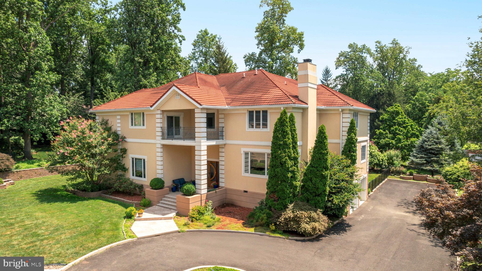 Welcome to this one-of-a-kind, custom-built estate tucked away on a private lot in the heart of desirable Huntingdon Valley. Thoughtfully designed with timeless elegance and functionality, this expansive single-family residence offers impressive square footage, soaring ceilings, and high-end finishes throughout.
As you enter the grand two-story foyer, you're greeted by an open, light-filled layout that seamlessly blends formal and casual living. To the left, a stunning two-story library/study with rich woodwork provides an inspiring space to work from home, while just a few steps up to the right, a sophisticated formal living room with a fireplace offers the perfect setting for gatherings or quiet evenings.
This level also includes a versatile bedroom with an en-suite bath, currently styled as a home office, as well as a spacious flex room ideal for a gym, playroom, or guest space. From the foyer, flow into the formal dining room and expansive chef’s kitchen, beautifully appointed with granite countertops, custom cabinetry, a Sub-Zero refrigerator, wall oven, wine refrigerator, and an oversized walk-in pantry. A conveniently located powder room and large eat-in breakfast area complete the space. Step out onto the oversized balcony, perfect for dining al fresco or enjoying serene views of the private backyard.
The kitchen opens to a dramatic two-story family room, featuring hardwood floors and a striking wood-burning fireplace, making it the heart of the home for entertaining or relaxing with loved ones.
Upstairs, you’ll find four generously sized bedrooms, each with its own en-suite bath and walk-in closet. The luxurious primary suite is a true retreat, featuring an enormous walk-in closet the size of a bedroom, and a spa-inspired en-suite bath with a soaking tub, separate glass-enclosed shower, and dual vanities.
An additional upper level offers even more living space with a private bedroom, walk-in closet, and full bathroom, ideal for extended guests or multi-generational living. This level also includes a large bonus room currently used for storage, but easily adaptable for a home theater, studio, or hobby room.
The walk-out lower level features a finished living area with ample natural light, perfect for a recreation space, additional family room, or media area, along with a generous unfinished section ideal for storage or future customization. This level also provides direct access to the oversized two-car garage.
With custom millwork, high ceilings, quality finishes, and an incredibly functional layout, this home offers the perfect blend of luxury and everyday comfort. Set on a beautifully landscaped private lot in a sought-after location, this is a rare opportunity to own a truly special home.
This extraordinary residence is a must-see for buyers seeking timeless design, thoughtful craftsmanship, and an abundance of space inside and out
