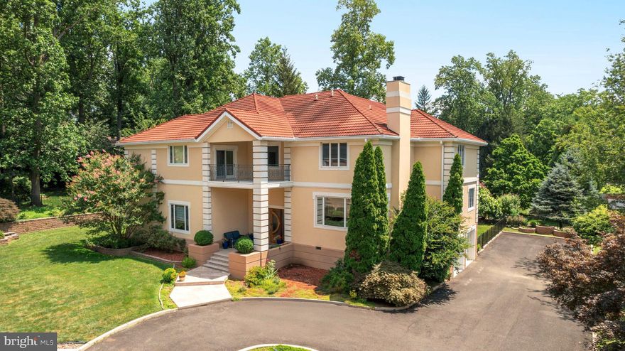 Welcome to this one-of-a-kind, custom-built estate tucked away on a private lot in the heart of desirable Huntingdon Valley. Thoughtfully designed with timeless elegance and functionality, this expansive single-family residence offers impressive square footage, soaring ceilings, and high-end finishes throughout.

As you enter the grand two-story foyer, you're greeted by an open, light-filled layout that seamlessly blends formal and casual living. To the left, a stunning two-story library/study with rich woodwork provides an inspiring space to work from home, while just a few steps up to the right, a sophisticated formal living room with a fireplace offers the perfect setting for gatherings or quiet evenings.

This level also includes a versatile bedroom with an en-suite bath, currently styled as a home office, as well as a spacious flex room ideal for a gym, playroom, or guest space. From the foyer, flow into the formal dining room and expansive chef’s kitchen, beautifully appointed with granite countertops, custom cabinetry, a Sub-Zero refrigerator, wall oven, wine refrigerator, and an oversized walk-in pantry. A conveniently located powder room and large eat-in breakfast area complete the space. Step out onto the oversized balcony, perfect for dining al fresco or enjoying serene views of the private backyard.

The kitchen opens to a dramatic two-story family room, featuring hardwood floors and a striking wood-burning fireplace, making it the heart of the home for entertaining or relaxing with loved ones.

Upstairs, you’ll find four generously sized bedrooms, each with its own en-suite bath and walk-in closet. The luxurious primary suite is a true retreat, featuring an enormous walk-in closet the size of a bedroom, and a spa-inspired en-suite bath with a soaking tub, separate glass-enclosed shower, and dual vanities.

An additional upper level offers even more living space with a private bedroom, walk-in closet, and full bathroom, ideal for extended guests or multi-generational living. This level also includes a large bonus room currently used for storage, but easily adaptable for a home theater, studio, or hobby room.

The walk-out lower level features a finished living area with ample natural light, perfect for a recreation space, additional family room, or media area, along with a generous unfinished section ideal for storage or future customization. This level also provides direct access to the oversized two-car garage.

With custom millwork, high ceilings, quality finishes, and an incredibly functional layout, this home offers the perfect blend of luxury and everyday comfort. Set on a beautifully landscaped private lot in a sought-after location, this is a rare opportunity to own a truly special home.

This extraordinary residence is a must-see for buyers seeking timeless design, thoughtful craftsmanship, and an abundance of space inside and out