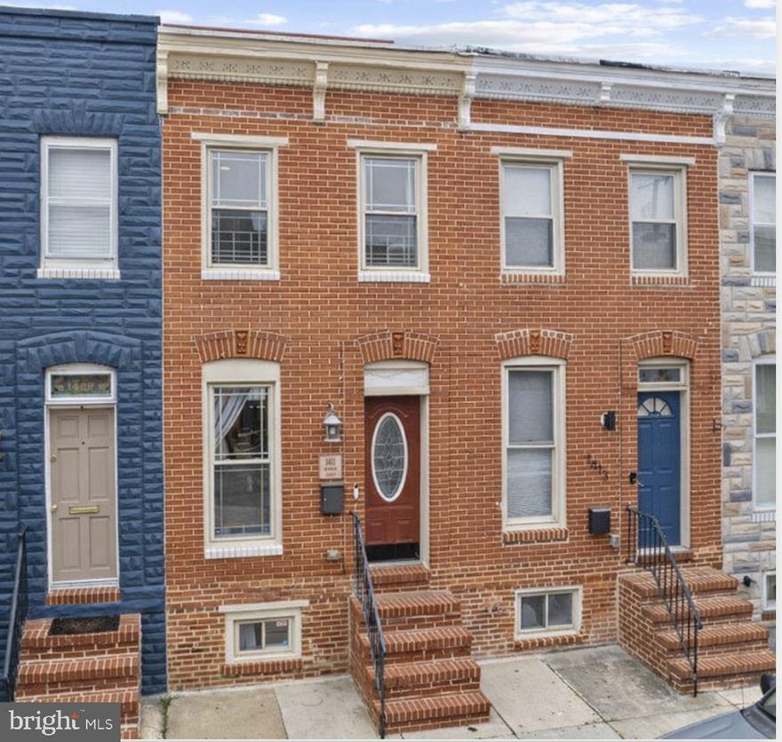 There’s an ease to this home that you feel right away. Nothing forced, nothing overdone. It just works.

Beyond the classic brick front, the main level opens to warm hardwood floors, exposed brick, and a coffered ceiling that gives the living room a sense of structure and character. The lighting feels intentional, and the space flows easily, with a convenient half bath tucked just where you need it.

The kitchen is clean, functional, and thoughtfully laid out with ample cabinetry, stainless appliances, and a tile backsplash. A custom butcher block workspace with added cabinetry brings extra prep space and storage, making the whole room feel more elevated and practical for everyday living. Just off the kitchen, a rear deck offers space for a bistro table or a grill, an easy spot to step outside and get some fresh air, with direct access to rare tandem two-car parking.

The finished lower level adds valuable flexibility, whether you need a second living space, workout area, or room to spread out, along with a dedicated laundry room with full-size washer and dryer and bonus storage space that’s always in demand.

Upstairs, hardwood floors continue throughout. The primary bedroom offers a comfortable retreat with its own private bath, while the second bedroom is well-sized and served by a nicely updated hall bath. A linen closet adds practical storage right where you need it.

And then there’s the roof deck. Open to the sky and tucked away just enough, it’s the kind of space you’ll find yourself using more than you expect as the days get longer and the evenings stretch on.

It’s the kind of home where day-to-day life feels a little simpler, a little more comfortable, and a lot more complete.