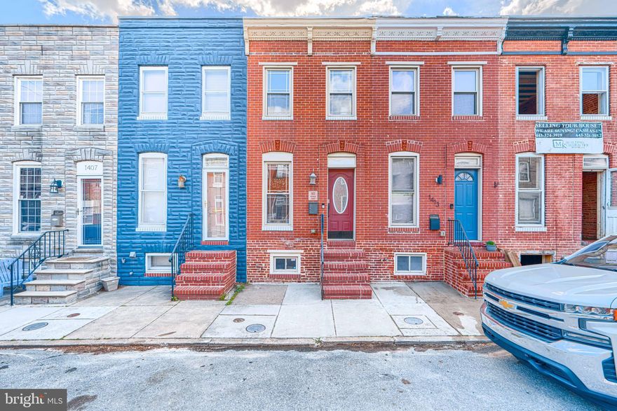 There’s an ease to this home that you feel right away. Nothing forced, nothing overdone. It just works.

Beyond the classic brick front, the main level opens to warm hardwood floors, exposed brick, and a coffered ceiling that gives the living room a sense of structure and character. The lighting feels intentional, and the space flows easily, with a convenient half bath tucked just where you need it.

The kitchen is clean, functional, and thoughtfully laid out with ample cabinetry, stainless appliances, and a tile backsplash. A custom butcher block workspace with added cabinetry brings extra prep space and storage, making the whole room feel more elevated and practical for everyday living. Just off the kitchen, a rear deck offers space for a bistro table or a grill, an easy spot to step outside and get some fresh air, with direct access to rare tandem two-car parking.

The finished lower level adds valuable flexibility, whether you need a second living space, workout area, or room to spread out, along with a dedicated laundry room with full-size washer and dryer and bonus storage space that’s always in demand.

Upstairs, hardwood floors continue throughout. The primary bedroom offers a comfortable retreat with its own private bath, while the second bedroom is well-sized and served by a nicely updated hall bath. A linen closet adds practical storage right where you need it.

And then there’s the roof deck. Open to the sky and tucked away just enough, it’s the kind of space you’ll find yourself using more than you expect as the days get longer and the evenings stretch on.

It’s the kind of home where day-to-day life feels a little simpler, a little more comfortable, and a lot more complete.