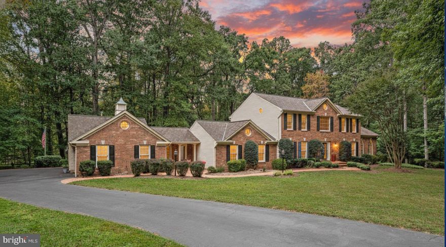 Incredibly hard to find–beautifully remodeled NV-built (a premium luxury builder) Harrington model with an oversized 3 car garage, sitting on a flat, lush 1.63-acre lot that sides to parkland on 2 sides in a lovely neighborhood location-close to everything! This expansive home feels as though it is situated on 5 acres, offers a manicured, landscaped, fully fenced lot lined w/ mature trees. Follow the brick walkway & exterior lighting to a dramatic entryway, where a 2 story foyer welcomes you with a large picture window that fills the space with natural light, an elegant farmhouse chandelier, and an open flow into the incredible custom floor plan.
Recently remodeled & upgraded, the entire home has been freshly painted in designer-selected colors & features new black matte hardware, luxury vinyl plank flooring, new plush carpeting, 3 renovated baths & much more! The main level offers a stunning, renovated kitchen with a center island, brand-new stainless steel appliances, premium granite countertops, a designer ceramic tile backsplash, skylight, recessed lighting, and a breakfast area highlighted by a bronze farmhouse light fixture. The enormous great room features a wet bar with custom glass-inlay cabinetry, granite countertops, a refrigerator, recessed lighting, built-in speakers, and a dramatic wall of windows with sliding glass doors opens to a 4 season enclosed porch w/ cathedral ceilings & a dedicated gas-lined stove. The stunning sunroom with cathedral ceilings is a true sanctuary of glass, featuring palladium and transom windows that frame breathtaking panoramic views of the surrounding nature. A renovated half bath: charcoal gray comfort-height vanity, designer mirror, updated lighting & modern fixtures. The formal living room, dining room with farmhouse lighting, and main-level office with a cozy fireplace all feature new luxury vinyl plank flooring, along with crown and chair rail moldings. A second covered front entrance opens into a mudroom with slate tile flooring and a main-level laundry room complete with white cabinetry, sink, storage closet, and direct access to the oversized 3 car garage.
Step outside from the kitchen and sunroom onto a huge Trex deck with PVC railings & stairs leading to a stone paver patio with built-in gas lines servicing both the stone fire pit and BBQ grill. An enormous stone terrace features a majestic outdoor stone fireplace with a slate hearth and steps leading to a gazebo and lush grassy yard – perfect for relaxing evenings and endless outdoor entertaining. Upstairs, the generous primary suite offers soaring cathedral ceilings, hardwood flooring, a walk-in closet, and a spa-inspired en-suite bath with heated radiant tile flooring, an oversized shower with dual showerheads and body jets, seamless glass doors, custom Italian tile throughout, top-of-the-line mahogany comfort-height vanity w/ dual Kohler sinks, modern lighting, recessed lights, skylight & abundant storage. The additional bedrooms all feature ample closet space, new ceiling fans with lighting, and plush new carpeting & share a renovated hall bath w/ black matte fixtures & modern lighting, a comfort-height vanity, recessed lighting & ceramic tile flooring.
Finished walk-out lower level offers a huge rec room w/ hardwood flooring, wainscoting & lots of recessed lighting, along w/ a newly renovated full bath featuring modern gold matte fixtures, contemporary lighting, a mid-century modern vanity & a walk-in shower. A spacious den w/ custom built-ins, closet & new modern lighting provides flexible living space. Large workshop room w/ workbench & shelving, plus an additional unfinished area for ample storage. BONUS: Premium scalloped architectural shingle roof (2021), 3 zone HVAC system upgraded in 2023 & 2026. 
Excellent location in the the heart of Northern Virginia: close to restaurants, food shopping (Whole Foods/Trader Joes) & outdoor recreation at Burke Lake Park, Marina,  Golf course & driving range.