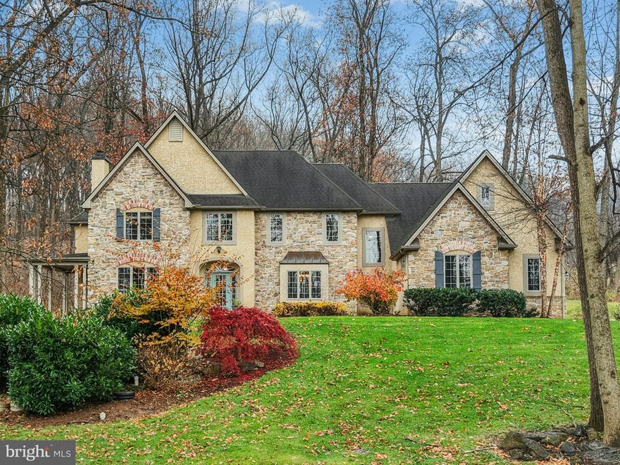 On a country road, set amongst tall trees on 2.5 acres, this French Country home overlooks beautiful Stouts Valley. Meticulously maintained and stylishly updated, the 4,736 square feet of family space is stunningly appointed.
Gleaming hardwood floors accent the first floor. A magazine-quality 2022 Jill Jarrett kitchen boasts a breathtaking blend of aesthetics and functionality, with high-end Sub Zero and Wolf appliances. White cabinetry, granite counters, coffee station, skylights and a center island are showstoppers.
There is a gracious dining and living room and a cathedral-ceilinged family room anchored by a floor to ceiling stone fireplace, bathed in light through oversized windows and skylights, opening to a stone terrace shaded by fabulous old trees. Completing the first floor is a sophisticated library and a full bath, doubling as a first floor bedroom.
Upstairs, the primary bedroom suite has a vaulted ceiling, a sitting room and bath with skylight, jetted tub and frameless shower. There are three additional bedrooms, two baths, a bonus room, and a back staircase. A three car garage and a lower level plumbed for a bath are the perfect extras.