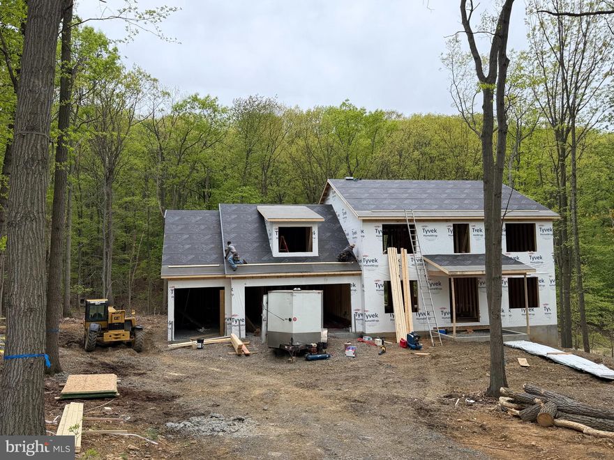 1.27 ACRE WOODED LOT IN Cumberland Valley Schools!  Black on black windows and cedar accents along with standing seam metal roofing gives this home a true LUXURY farmhouse feel.  This beautiful new home, built by 1st Advantage Construction, offers 5 bedrooms and 3½ bathrooms with a thoughtful layout designed for comfort and everyday living.  On the main floor (all hardwood floors), you’ll find a spacious dining room with elegant tray ceilings and farmhouse style trim—perfect for hosting family dinners and holiday gatherings. There is also a private office with stylish coffered ceilings, giving you a quiet and impressive space to work from home. The large family room features a cozy gas fireplace, custom built-ins, and an open layout that flows directly into the kitchen, making it ideal for entertaining.  The kitchen is truly the heart of the home. It includes custom handmade cabinetry, granite countertops and backsplash, and an oversized 8-by-4-foot island that provides plenty of room for meal prep, cooking, serving, and gathering. Just off the kitchen is a convenient mudroom with a built-in bench and cubbies to neatly store coats, shoes, and backpacks.  Upstairs, the primary suite is a true retreat. It offers generous space, a private sitting area, and a massive 13-by-7-foot walk-in closet. The primary bathroom includes double vanity, a private water closet, and a large walk-in tiled shower designed for comfort and style.  The finished walk-out lower level adds even more living space. It includes a large recreation room, a full bathroom, and an additional spacious bedroom—perfect for guests or extended family. Rough in for future wet bar.  There are also two unfinished storage areas that provide plenty of room to keep everything organized.  The home also features a large three-car front-entry garage with extra space in the rear for additional storage, tools, or a workshop area.  This home offers the opportunity to enjoy modern design, generous space, and quality craftsmanship in every detail.  The home is under construction and should be completed late July or early August.