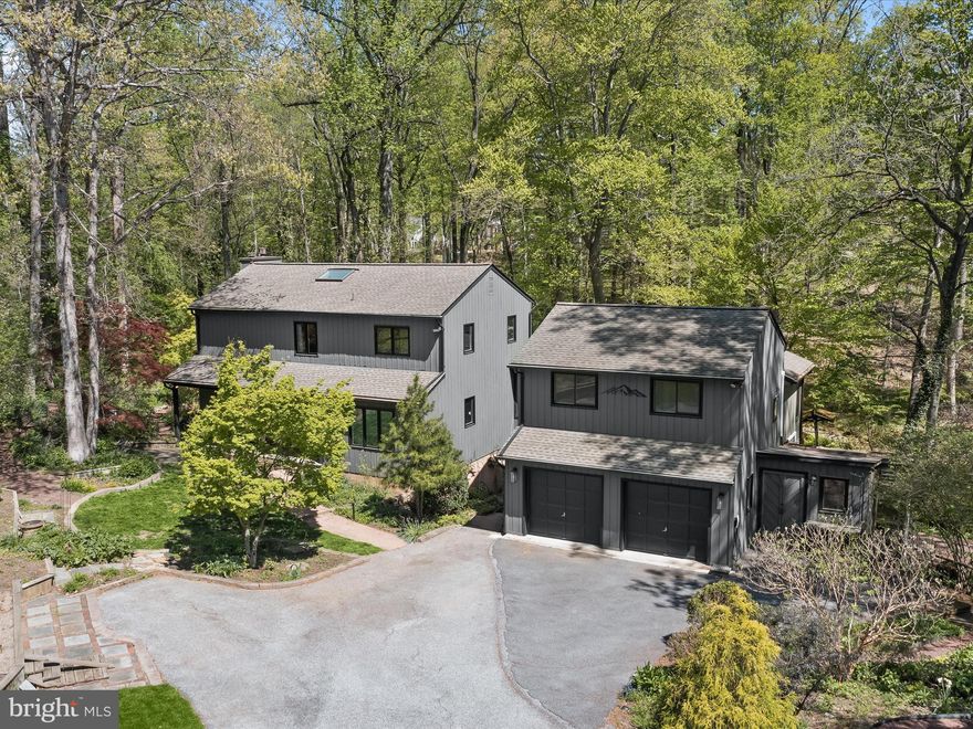 Situated on a serene cul-de-sac, this stunning scenic retreat offers an unparalleled blend of modern comforts and natural beauty. Boasting extensive renovations and a secluded lot, the home is a haven for outdoor enthusiasts, featuring multiple decks, a charming stream, a custom fire pit, outbuildings, a greenhouse, a workshop, and the ultimate covered front porch. A separate wing with its own entrance provides endless possibilities, making it ideal for an in-law suite or an income-generating space.
The main house is bathed in natural light, with expansive windows framing picturesque views from every angle. Gorgeous hardwood floors flow throughout the main living areas, creating a warm and inviting ambiance. The living room, spacious and serene, is perfect for unwinding, while the dining room boasts a cozy fireplace and access to a private deck, perfect for morning coffee or evening drinks. The lovely kitchen is outfitted with stainless steel appliances, gas cooking, custom cabinetry adorned with stained glass, decorative lighting, a wall of windows, and a walk-in pantry. A second deck off the kitchen adds extra convenience. Upstairs, the primary suite is a luxurious retreat featuring a dual walk-in closet, a ceiling fan, an additional closet, and a spa-like ensuite bath. Renovated to perfection, the bathroom dazzles with a wall of windows, skylights, dual vanities, and an oversized shower. Two additional bedrooms with hardwood floors and ceiling fans, along with a full bath, complete the upper level. The lower level extends the living space with a fourth bedroom, a recreation room, a full bath, a laundry room, ample storage, and walkout-level access. The tastefully completed separate wing is equally impressive, offering a swanky living area with a wet bar, two additional bedrooms, an office, storage, and a full bath. This space is perfect for extended family, guests, or potential rental income. Recent updates include a new HVAC system, furnace humidifier, generator, windows, mini-splits in the office and guest room, insulated ceilings and floors, a remodeled kitchen, primary bath, and main-level powder room, a finished separate wing, interior painting, rewiring, a heat pump with a 10-year parts warranty, a water heater in the workshop, a Tesla charger, an electric fence, exterior home painting, exterior lighting, and a custom fire pit. This extraordinary home is a must-see, offering a lifestyle of comfort and endless possibilities. Don’t miss out on this incredible opportunity!