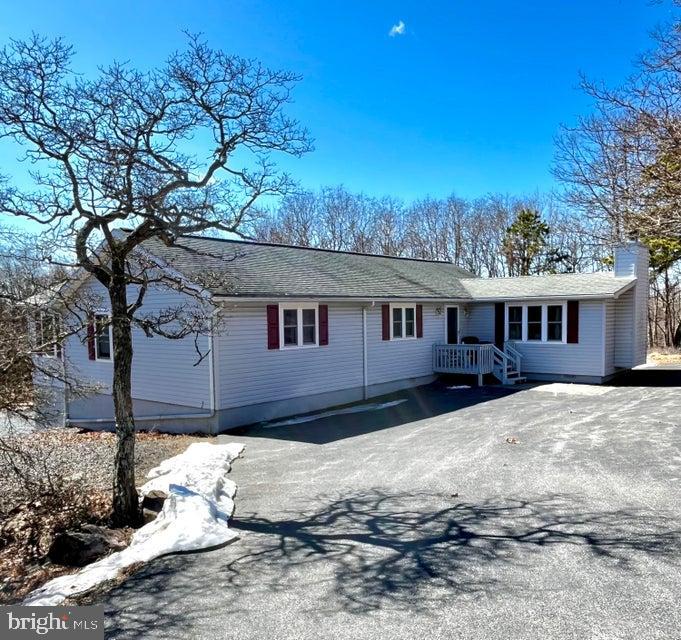 Talk about your amazing spaces!! You've got to see this 24'X40' garage-shop with separate driveway and entrance. It's got it's own electric and wood stove. House has been lovingly maintained by same owner since 1970s and now it's time for someone else to call it home. maintenance-free exterior, 3 spacious bedrooms, living room with propane fireplace, plus adjacent den or formal dining area, sunny eat-in kitchen with sliders to deck, lower level garage and additional storage, 1.5 baths and all living space on one floor - located on 1 acre+ corner level lot within short walk to outdoor pool and tennis courts. Seller will pay $1230 capital improvement fee with acceptable offer. STR-friendly development with 5 lakes, 2 pools, clubhouse, manned security gates, paved roads and trash pick up.