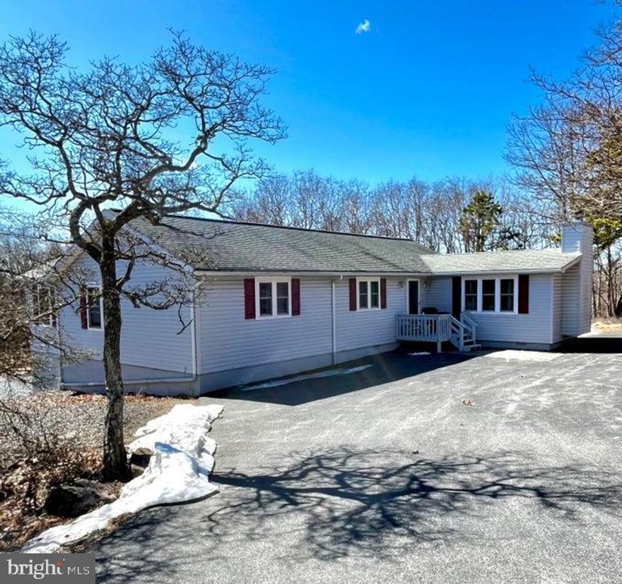 Talk about your amazing spaces!! You've got to see this 24'X40' garage-shop with separate driveway and entrance. It's got it's own electric and wood stove. House has been lovingly maintained by same owner since 1970s and now it's time for someone else to call it home. maintenance-free exterior, 3 spacious bedrooms, living room with propane fireplace, plus adjacent den or formal dining area, sunny eat-in kitchen with sliders to deck, lower level garage and additional storage, 1.5 baths and all living space on one floor - located on 1 acre+ corner level lot within short walk to outdoor pool and tennis courts. Seller will pay $1230 capital improvement fee with acceptable offer. STR-friendly development with 5 lakes, 2 pools, clubhouse, manned security gates, paved roads and trash pick up.