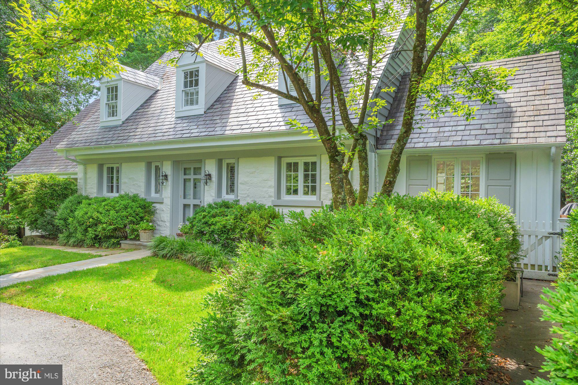 OPEN SUNDAY 2:00-4:00. Welcome to this stunning 5-bedroom, 4.5-bath home on a spectacular .45-acre lot in the sought-after enclave of Chevy Chase Hills. This exceptional property with over 4000 sq ft of living space offers a rare combination of timeless elegance, thoughtful renovation, and modern livability—set amid lush, manicured grounds with an in-ground pool, extensive flagstone patios, and a striking serpentine stone wall that extends from front to back.
Recent renovations include a stunning reimagining of the main-level primary suite, now featuring wide-plank wood floors, added windows, and a spa-inspired ensuite bath. A renovated powder room, new appliances and countertops in the eat-in kitchen, updated lighting and hardware throughout, new carpets and stair runners, and new gutters reflect the seller’s meticulous attention to detail. Agents: please inquire for comprehensive list of upgrades.
The gracious main-level floor plan is designed for both everyday comfort and effortless entertaining. The large living room with newly added custom built-ins flows effortlessly between the formal dining room and sunroom which opens directly onto the patio, and a newly constructed IPE deck seamlessly connects the main-level primary suite to the sunroom from the outside—creating a true sense of indoor-outdoor flow. Newly installed HVAC systems now serve both the sunroom and dining room areas, ensuring year-round comfort. French doors from the kitchen open to a private patio—ideal for al fresco dining and entertaining.
Upstairs, the flexible layout offers additional bedrooms with a shared bath, plus a second primary suite with an ensuite bath and a large private sitting room.
The expansive lower level (1208 sq ft) offers impressive functionality and comfort, including a spacious fifth bedroom, full bathroom, and a large recreation room—perfect as a second family room, game room, or home theater. Custom built-ins on this level include an entire wall of sleek base cabinetry, dual built-in refrigerator and freezer drawers for entertaining, and a supplemental freezer in the storage area. A generous laundry room and two storage rooms complete the space, which connects directly to the surrounding patios.
Enjoy a bucolic setting just minutes from the shops and dining of Chevy Chase Lake and future Purple Line Metro access. This is a truly extraordinary offering that combines refined architecture, exceptional flow, and magazine-worthy outdoor living in one of the area’s most desirable neighborhoods.