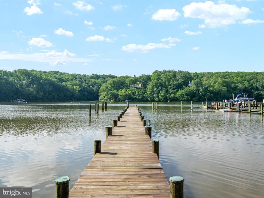1486 Downham Market is the ultimate Annapolis deep-water estate—designed for those who demand luxury, security, and boating excellence. Perfectly positioned at the mouth of Clements Creek—one of the safest hurricane holes on the Severn River—this home pairs architectural brilliance with one of the region’s most coveted waterfront settings.  A commanding 180’ pier with three boat slips, 50-amp power, and 11’ MLW welcomes yachts and sport boats alike—Hinckley, Viking, Boston Whaler, Pursuit, or Chris-Craft—this property can handle them all. Reinforced pilings are ready for lifts, making this a boater’s dream with full riparian rights. From here, you’ll be on the Severn and Chesapeake Bay in minutes.  Inside, walls of glass frame sweeping water views from nearly every room. Across three levels, the transitional design blends clean lines with warmth: hardwood floors, designer lighting, and soaring ceilings. The chef’s kitchen is fully outfitted with commercial-grade appliances, granite counters, and gas cooking, flowing into multiple living and dining areas anchored by a dramatic two-sided stone fireplace.  The primary suite is a true retreat—private sitting room and fireplace, a spa bath with skylight, soaking tub, glass shower, and custom walk-in closet. Additional ensuite and Jack-and-Jill bedrooms provide comfort and privacy for family or guests. The walkout lower level is built for entertaining with a rec room, wet bar, wine storage, gym, fifth bedroom, full bath, and a glass-wrapped sunroom ready for a hot tub retreat.  Outdoor living is extraordinary: multi-level decks, panoramic views, and serene waters that stretch toward the Severn and Bay. A brand-new septic system and advanced water treatment with reverse osmosis and UV protection offer peace of mind.  Set in the prestigious Downs on the Severn, residents enjoy two marinas, clubhouse, pool, tennis and pickleball, and a close-in location to Annapolis, D.C., and Baltimore.  Waterfront estates of this caliber almost never hit the market. 1486 Downham Market is ready now—bring your yacht, bring your lifestyle, and claim your place on the Severn.
