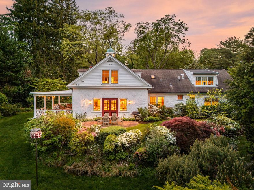 Rare treasure. Exquisitely renovated stable with separate guest cottage tucked privately on enchanting grounds a stone’s throw from the Merion Golf Club. Once part of the historic Millbrook Farm estate, this property has been transformed with style and grace, blending original character with modern sophistication.
Thoughtfully reimagined by an Owner with an exceptional gift for design, and executed by a second-generation craftsman/Builder (whose father also renovated the stable in 1985), the home is rich with legacy and layered detail. Original 22-inch stone walls and exposed columns on both levels honor the building’s equestrian roots. Thoughtful touches—soft jute rugs, exposed beams, sliding barn doors, fine antique hardware, a perfectly placed Dutch door, beadboard paneling, and well-placed skylights—create a depth of authenticity rarely found. 
As featured in Main Line Today, the experience begins as French Spanish cedar double doors open to a vaulted entryway, highlighted by a skylight and V-groove paneling. Wide-plank reclaimed heart pine floors with black walnut plugs guide you into a beautifully designed living space. The intimate dining room, wrapped in knotty pine paneling with coffered ceiling and anchored by a striking light fixture, gives way to a warm, open-concept kitchen and family room. The custom-designed kitchen features open shelving, white Kountry Kraft cabinetry, Carrara marble countertops, and classic white subway tile. An oversized wormy chestnut butcher-block island with a farmhouse sink serves as the centerpiece, illuminated by a pair of lanterns echoed in the adjacent living space. A cobalt-blue range adds a stylish punch of color. Additional sets of French Spanish cedar doors connect the interior seamlessly to a terrace on one side and large covered porch on another, an indoor-outdoor flow that is perfect for entertaining. The cozy family room boasts deep silled windows, exposed brick detail and is finished with a slate surround gas fireplace. Every inch of the space invites you to gather, truly serving as the heart of the home. A powder room and coat closet at the entry complete the main living space. 
The highly sought after first-floor primary is enveloped with views of the private grounds. Its sumptuous bathroom boasts high ceilings, steam shower with metal-framed glass door, double vanities, and sleek Hamilton Sinkler chrome fixtures. The built-in soaking tub with Carrara marble deck is tucked beneath a window, which was formerly part of a stable door. A walk- in closet is accessed off the primary bathroom. A thoughtfully organized laundry suite with sink and more Carrera marble countertop finishes off the primary suite. 
Upstairs, the former hayloft has been transformed into a retreat with three bedrooms and a central sitting area. Two of the bedrooms enjoy full bathrooms with immaculate white subway tile. The third includes a clever ensuite with toilet and sink, and can access both full baths from the hallway. Sliding barn doors provide privacy while preserving the open, loft-like ambiance. 
Step outside and follow a brick path to the fully renovated cottage. This space offers even more versatility, with a small kitchen, gas fireplace, and full bathroom. Ideal for guests, a studio, or a private office. A detached garage offers one standard bay and a second bay perfect for a sports car. 
Surrounded by mature specimen trees and curated landscaping, the grounds are both serene and vibrant. An in-ground pool is enhanced by a reimagined patio, perfect for summer relaxation. Cobbs Creek begins on the property, adding the soothing sound of a nearby waterfall—creating a magical and meditative setting. A beautiful masonry wall punctuates the property with more historic charm.  
Extremely special, private oasis in a very central Main Line location. One mile to Haverford town center and train station, a walk to the Haverford College Nature Trail. Commuters’ dream close to all major roadways