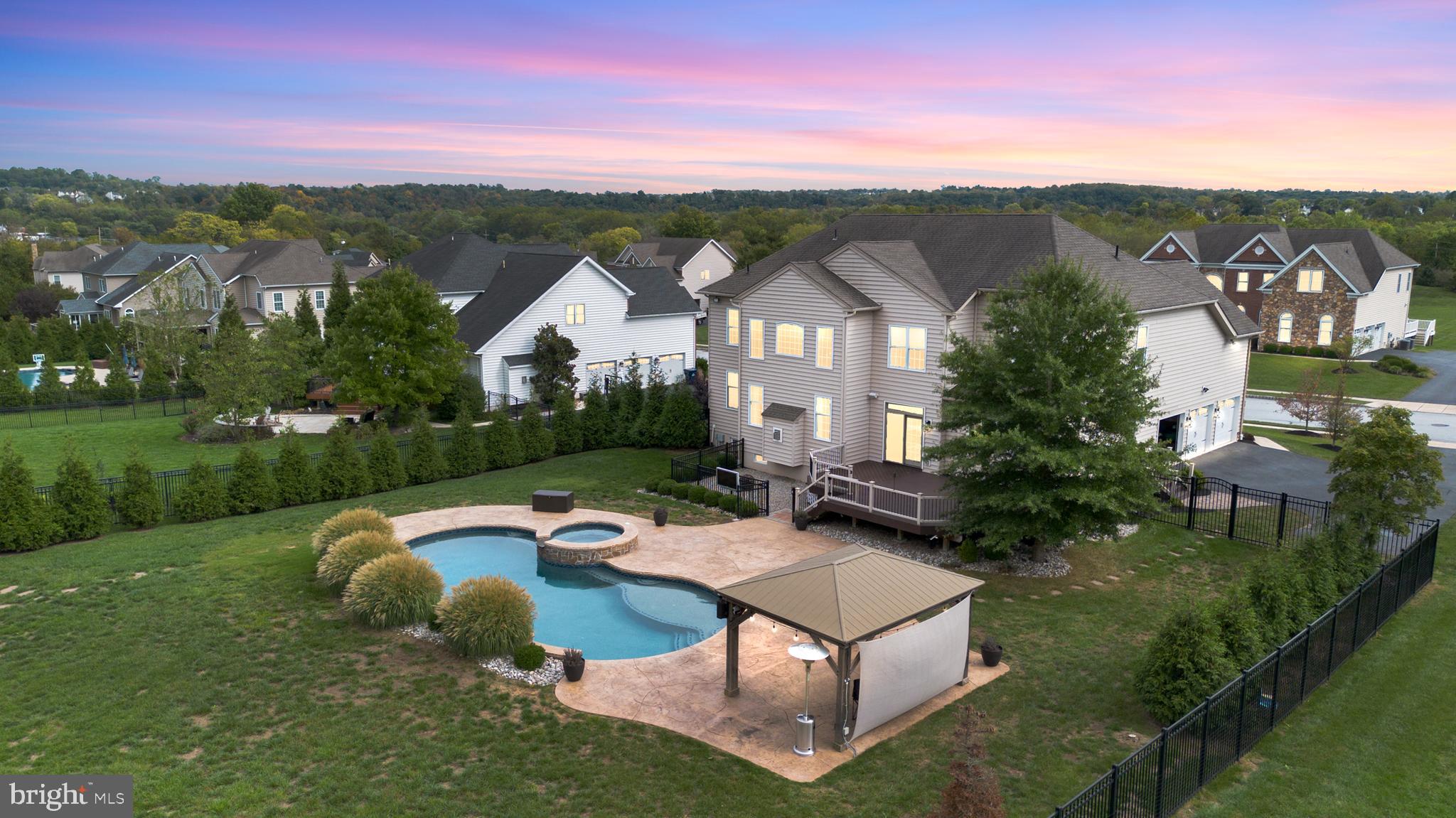 Nestled in the heart of Riverside at Providence, within the esteemed Spring-Ford School District, this exceptional "smart" residence stands out as a truly unique property without the wait of New Construction and this Home Has it All! Guests are welcomed into a luxurious residence that surpasses expectations. A grand entry hall sets a regal tone with a sweeping staircase leading to a spacious two-story family room with a stone fireplace and a wall of windows that let natural light in, and a custom coffered ceiling and New Mercier Engineered Hardwood flooring on the 1st floor and hallway of the 2nd level. Chef's Kiss gourmet kitchen with a vast custom black island, upgraded stainless steel appliances with 6 burner commercial range and an over-the-top custom walk-in pantry, accompanied by a charming breakfast room that invites culinary exploration. A cozy study offers a serene retreat for contemplation. To complete the first level, a luxurious dining room, living room, tiled mudroom with a double stack washer and dryer, and a powder room. The primary suite serves as a private sanctuary, featuring a comforting den, a dedicated dressing room with vanity, three walk-in closets, laudry room, and an indulgent bathroom sanctuary. Three additional bedrooms and a princess suite ensure ample accommodation for both family and guests, ensuring everyone enjoys privacy and comfort. However, the allure of this home extends beyond your imagination. Whether hosting a grand gathering or relishing quiet moments, the custom fully finished basement space provides an idyllic setting for both entertainment and relaxation with a home theater, professional custom bar with ice maker, dishwasher, tap Kegerator, wine fridge, wine closet, full custom bath, fifth bedroom, and plenty of room for game nights. Discover an enchanting outdoor retreat beyond the sliders, complete with a deck, TV, cabana, fire pit, and inviting seating areas. Majestic, mature trees and landscaping enhance the ambiance, transforming the surroundings into a true resort-like paradise. It is the ultimate entertaining space. Finally, the pièce de resistance awaits: the magnificent gunite pool with custom water features, ideal for scorching days orheated for fall the fall months, that embodies both luxury and practicality. Highlights include: Stamped concrete, 3-car heated garage, covered front porch, proffesional landscaping and up- lighting, custom lighting, kitchen island revamp, recessed lighting, and surround sound all controled by this smart home. This home will not last! Schedule your tour today.