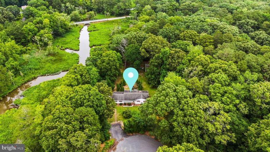 Nestled at the end of a quiet cul-de-sac on a peaceful, tree-lined street, this nearly 2-acre property offers a rare opportunity for the right buyer to transform a house in need of major rehab into a stunning retreat. Set on a beautiful lot that gently slopes toward a picturesque, flowing stream, the setting is ideal for nature lovers and outdoor enthusiasts alike—with the ability to launch a kayak or paddle board right from your backyard. The home offers an expansive open floorpan with a large eat in kitchen,  three generous size bedrooms/two full  bathroom including a primary en suite, and half bathroom off the kitchen . With its incredible potential, serene surroundings, and access to water, this is a dream project waiting to be realized. This sale comes with two lots. The front lot is .77 acres and the lot behind it is .918 totaling 1.688 total acres.