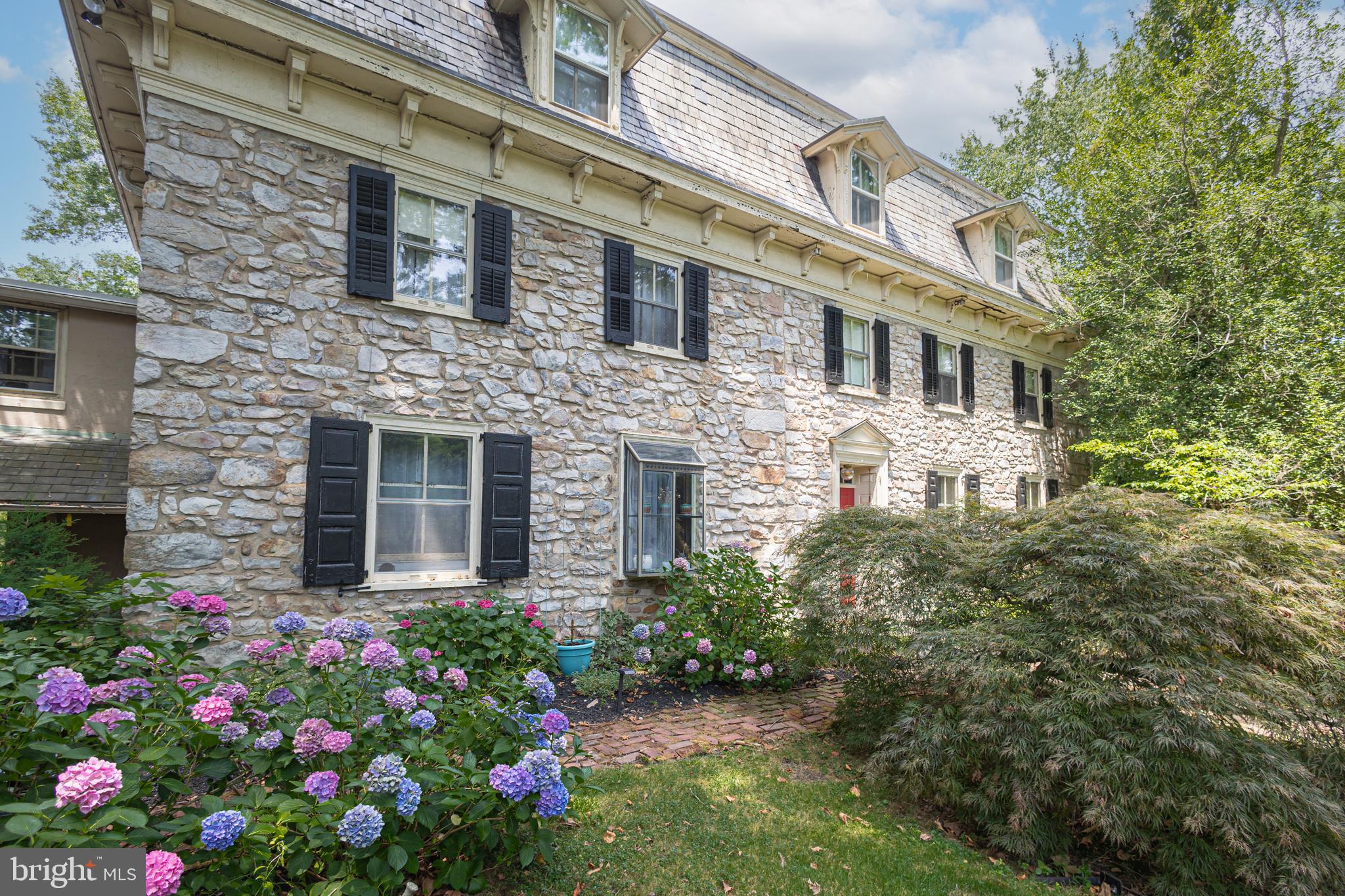 If you want to immerse yourself in Bucks County life surrounded by fresh air, countryside fields and farmland, Mill Creek Farm, a wonderful farmstead has what you are looking for and more! Nicely nestled on 14+ scenic acres, this circa 1730s historic property, once a quaint B&B, offers endless amenities beginning with an original stone manor, 13-stable horse barn, summer kitchen, corn crib, tennis court, pool with hot tub and a pond. Over the years the barn has been converted and renovated into 5 income producing apartments yet still keeping the horse stables intact along with two birthing areas that were used to breed thoroughbreds, making it very much a working farm in its day. The main house includes 5 bedrooms, 5 full baths and a convenient half bath. The rooms are comfortable with period dated hardware, deep windowsills, exposed ceiling beams and exposed stone walls. A favorite space in the manor is the enclosed porch adorn with bar and several sitting areas overlooking the Lahaska Creek flowing through the back of the property where you can rest in front of the stone fireplace and enjoy the picturesque views. At night you can step outside for backyard fireside chats by the creek and see a full sky of stars while listening to the sounds of nature or relax in the other delightful outdoor living areas such as the cozy spot by the summer kitchen known as The Crape Myrtle Pub with bar offering indoor and outdoor seating. A bonus find on the third floor are the rare high ceilings and two private bedrooms with bonus storage. Perfect for a family compound and/or equestrian enthusiast this farm is situated about a mile away from town; along a quiet country road - Quarry Road, named after a quarry that used to exist a long time back at the end of the road which supplied the stone that gives the distinctive style to the buildings in the area. Overlooking green pastures, apple orchards, a pond and acres of serene gardens yet convenient to many Bucks County attractions and close to Doylestown, Lahaska’s Peddlers Village, and New Hope with its assortment of eateries and shops. Experience the peaceful grounds of this horse farm where William Penn held the farm’s first deed and immerse yourself in the country scenery and you’re sure to fall in love with this unique property!