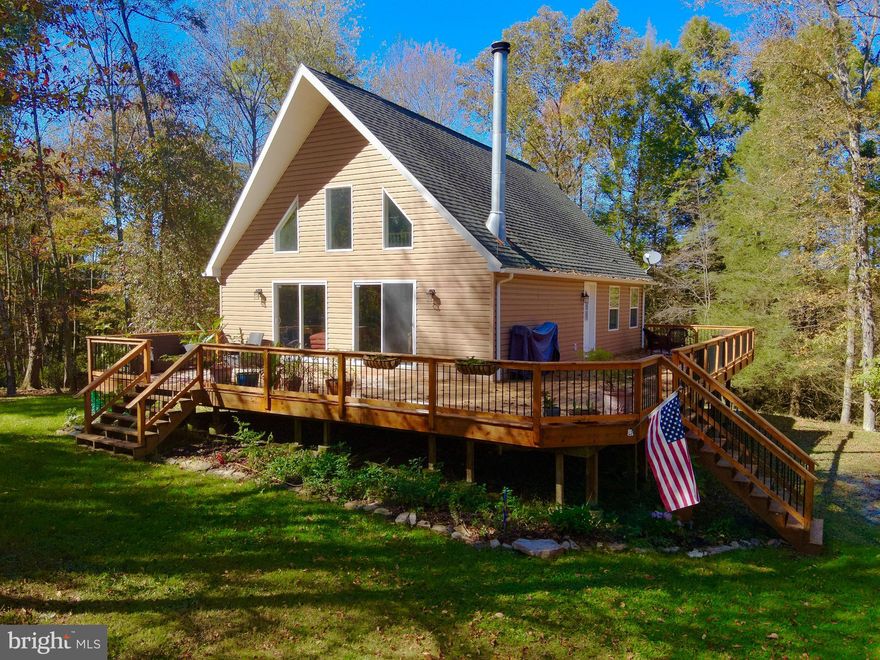"Welcome to Wild Flower" Just 6 +/- miles from I-68 and Bruceton Mills this 1,700 +/- sqft, 3 bed/ 2 bath home on 6.28 ACRES awaits! Tucked back in the pines this property offers total solitude as you listen to Big Sandy Creek meander through the mountains. Out the front door enjoy a newly constructed 980 sqft partial wrap around deck leading into a flat, wooded front yard. This property offers riding & hiking trails, meandering creek with waterfalls, mature timber, and abundant wildlife including deer and turkey. Inside, this home features an open floor plan, floor to ceiling stone fireplace, 415 sqft loft bedroom, upgraded hardwood pine doors, luxury vinyl plank flooring, and new water filtering system. An expansive, 10ft ceiling, step out basement awaits finishing to your needs. For peace of mind, a full house generator provides reliable backup power for the home. Take in the sunrises with a hot cup of coffee as the spring birds chirp or share your favorite beverage with friends around your very own, private fire pit. This $250/year rural HOA includes road maintenance and snow removal for easy to and from. Additional land available. Enjoy total seclusion with just a short drive to I-68, 20 +/- miles to Cheat Lake /Morgantown, 30 +/- miles to Deep Creek Lake, 15 +/- miles to Coopers Rock State Park, 100 +/- miles to Pittsburgh, PA.