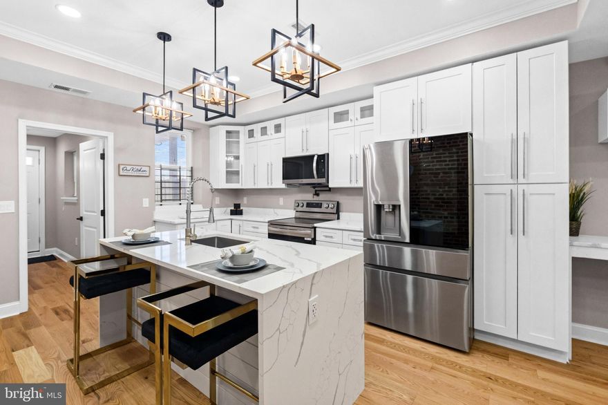 You don’t move to Baltimore to play small.
You move here to build a life that looks good on you.

Welcome to 2785 The Alameda.

Set on one of the widest and most iconic historic boulevards in Baltimore City, this fully renovated five bedroom, four bath home gives you 2,000 square feet of intentional design, real craftsmanship, and the kind of presence that turns heads before you even walk in. Mature flowering trees line the parkway. Green space frames your view. Two-way traffic makes access easy. The block feels established. The home feels brand new.

Open the 36” designer front door and the tone shifts immediately. Coffered ceilings. Crown molding. Geometric ceiling and wall detail. A full exposed brick feature wall that runs along the first floor and continues upstairs. Red oak hardwood floors (solid wood) Four oversized electric fireplaces create warmth and symmetry throughout the home.

The staircase anchors the space with red oak steps, matte black iron single basket balusters, and custom red oak rails that give architectural feel. Natural light pours through a 3 x 3 ft skylight above, making the hallway brighter and more expansive than you expect in a city row home.

The kitchen is built for someone who entertains. Quartz countertops. Sixteen all-wood framed cabinets including a lazy Susan and a dramatic 96” pantry. A six-foot island transitions seamlessly into a dry bar and dining area. LG ThinQ smart appliances complete the space, including a 29 cu. ft. InstaView French door refrigerator, exterior-vented microwave, dishwasher, and electric stove. This is not builder grade. This is curated.

Slide open the six-foot Pella patio door and step onto a private 15x15 ft deck with a side privacy screen and a panoramic residential skyline views. The indoor-outdoor flow makes the second bedroom feel like an open concept extension of your living space. The backyard offers a newly poured reinforced concrete pad, gated parking, shadow fencing, and motion-activated lighting for added security.

Upstairs, the primary suite gives you three large grilled bay windows with skyline views and space to breathe. Four of the five bedrooms range from 150 to 200 square feet, which means you can finally have the home office, gym, guest room, or creative studio you’ve been talking about. Each of the four bathrooms is fully modern and uniquely styled with coordinated fixtures and thoughtful finishes.

The fully finished basement expands your options even further. A six-foot French door opens to a spacious rec room or private bedroom suite. There is a separate basement exit and stairwell.  You  also get a sump pump and sewage extraction system for added protection.

Behind the walls, everything is new. Plumbing. Gas. Electrical systems. A new 2.5 ton heating and cooling system. A new roof. A 40 gallon electric water heater. Front-loading washer and dryer. All rooms are cable ready. This home is as solid as it is beautiful.

And yes, it qualifies for Baltimore City grants, which means your move could be smarter than you think.

If you are a young professional building your footprint in Baltimore or a long-term resident ready to upgrade your space, this is the kind of home that matches your momentum.

2785 The Alameda is not just renovated.
It is reimagined.