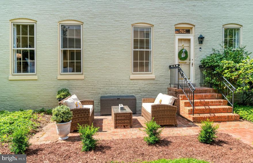 Perfectly positioned in the heart of Old Town, this exceptional Swann Daingerfield condo offers the rare convenience of single-level living on the main floor, complete with a private brick patio framed by lush plantings. 
The living room showcases over 11-foot ceilings, striking 8-foot windows, a fireplace flanked by custom bookcases, and original heart pine floors that accentuate the historic millwork. An adjacent dining room, featuring another tall window and a dramatic oval window, creates a breathtaking setting elevated by custom wine bar cabinetry.
The chef’s kitchen exudes character with a shiplap ceiling, soapstone counters, high-end appliances including Bosch stove and dishwasher, and a stylish backsplash. A hall lined with storage closets leads to two generous bedroom suites overlooking the gardens. The primary suite delights with an enormous walk-in closet and a beautifully renovated bath. A wall of custom cabinetry allows for even more primary room storage needs. The second suite also includes a wall of custom cabinetry, as well as ample closet storage, and updated private bathroom.
Additional conveniences include a deeded assigned parking space (#2) and a private lower-level 10 x 8 foot storage unit for oversized belongings.
This home masterfully blends the Old Town elegance with modern comforts—soaring ceilings, massive windows, and thoughtful renovations—making it truly one-of-a-kind. Built in 1802, own a piece of history at Swann Dangerfield condominium. Just moments away from the phenomenal restaurants and shopping that Old Town Alexandria has to offer.