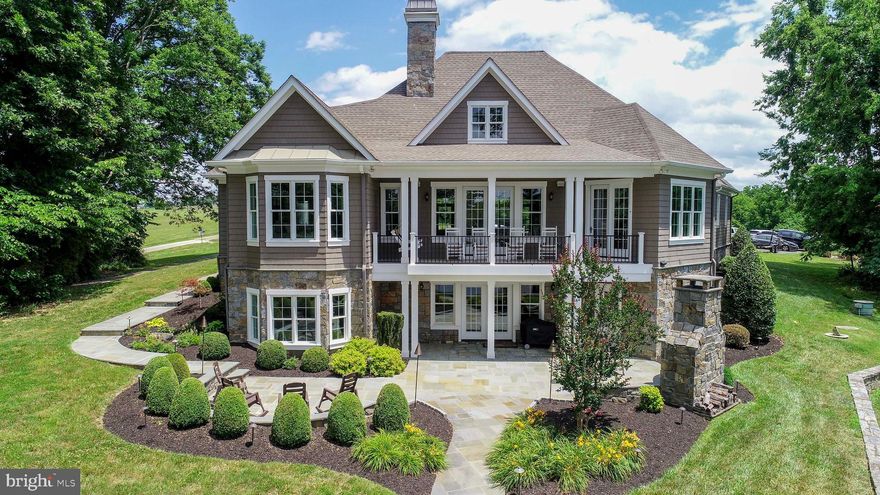 Wake up to sparkling lake views, spend your days on the water, and end each evening with breathtaking sunsets that paint the sky—this extraordinary custom-built waterfront home captures the very best of life on Lake Anna. Designed with a perfect balance of luxury, comfort, and timeless craftsmanship, this remarkable 5-bedroom, 4.5-bath residence offers over 200 feet of pristine deep-water frontage, with approximately 15 feet of depth at the end of the dock, and sweeping unobstructed lake views from nearly every room.  The thoughtfully designed open-concept main level creates an effortless flow between the gourmet kitchen, dining area, and the stunning Great Room, making it ideal for both everyday living and entertaining. The chef’s kitchen features high-end appliances, generous counter space, and custom cabinetry, seamlessly connecting to the dining area—perfect for intimate meals or lively gatherings with family and friends. Anchoring the space is the Great Room, where soaring ceilings, a dramatic stone fireplace, and a wall of windows frame spectacular lake views while filling the home with natural light. 
The main-level primary suite offers a peaceful private retreat, complete with tray ceilings, expansive windows overlooking the water, and a spa-inspired ensuite bath designed for relaxation. Four additional bedrooms and beautifully appointed bathrooms provide ample space and comfort for family and guests.  
Exceptional craftsmanship continues outdoors, where elegant stone columns welcome you at the driveway entrance and natural materials enhance the landscape with flagstone porches, walkways, and patios. The 200-foot natural stone bulkhead and seawall provide both beauty and shoreline protection, while multiple outdoor living areas invite you to fully embrace the lake lifestyle. Enjoy cooking and entertaining at the built-in grill island, gathering around the stone fireplace on the rear patio, or relaxing by the separate firepit area under the stars.  The oversized dock is truly a boater’s paradise, featuring two covered boat slips with lifts, a spacious sun deck, Gorilla Deck composite decking, storage with electricity and running water, hard-wired internet, and a Sonos sound system with eight speakers. Four floating jet ski docks make it easy to enjoy every water activity Lake Anna has to offer.  Additional highlights include a paved driveway, oversized 28x28 garage, whole-house audio system, central vacuum, and most furnishings conveying with the sale—making this home as convenient as it is beautiful.  Whether you are searching for a full-time waterfront residence or a luxurious lakefront retreat, this exceptional property delivers refined design, premium amenities, and unforgettable views. From peaceful mornings on the dock to sunset gatherings by the firepit, every day here feels like a vacation.