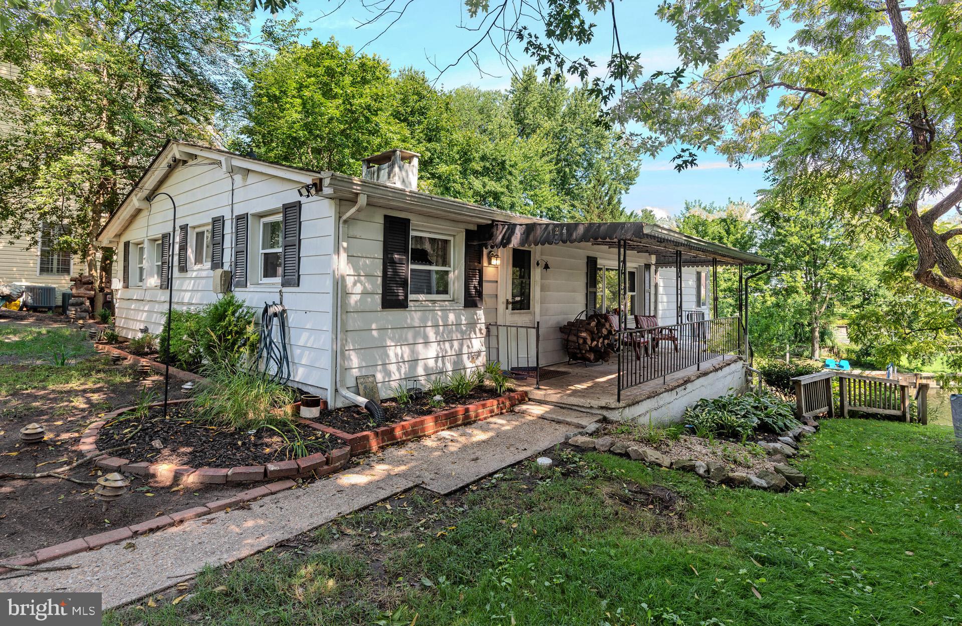 Chesapeake charm awaits at this waterfront cottage tucked along a quiet cove off Rock Creek! Whether you're seeking a weekend retreat or year-round living, this 2-bedroom, 2.5-bath home offers incredible potential with water views from both the living and family rooms. The great room features wood-paneled walls, beamed ceilings, and a masonry fireplace—perfect for cozy evenings. A separate family room with adjoining bedroom and bath makes an ideal in-law setup. The finished lower level includes a rec room, full bath, laundry/utility room, and walkout to a 3-season room with water views—plus potential for a 3rd bedroom. Bulkheaded shoreline is perfect to tie up your jet ski or small boat, and just a few doors down, enjoy access to the community’s private docks, boat storage, and clubhouse. This cooperative requires Board approval, owner-occupancy, and may limit some financing options. The cooperative owns the 5 acres of property on the water, so you own the home, not the lot. Home needs complete renovation, but offers a rare opportunity to create your dream waterfront escape at an affordable price!