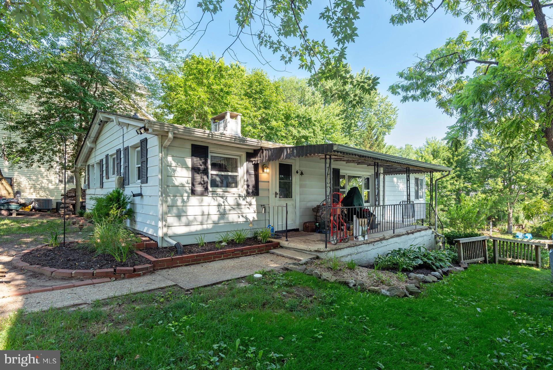 Chesapeake charm awaits at this waterfront cottage tucked along a quiet cove off Rock Creek! Whether you're seeking a weekend retreat or year-round living, this 2-bedroom, 2.5-bath home offers incredible potential with water views from both the living and family rooms. The great room features wood-paneled walls, beamed ceilings, and a masonry fireplace—perfect for cozy evenings. A separate family room with adjoining bedroom and bath makes an ideal in-law setup. The finished lower level includes a rec room, full bath, laundry/utility room, and walkout to a 3-season room with water views—plus potential for a 3rd bedroom. Bulkheaded shoreline is perfect to tie up your jet ski or small boat, and just a few doors down, enjoy access to the community’s private docks, boat storage, and clubhouse. This cooperative requires Board approval, owner-occupancy, and may limit some financing options. The cooperative owns the 5 acres of property on the water, so you own the home, not the lot. Home needs complete renovation, but offers a rare opportunity to create your dream waterfront escape at an affordable price!