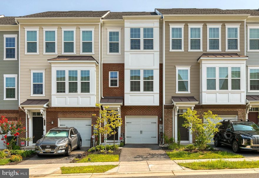 Almost new construction!  This 1 car garage townhome has been lovingly maintained and offers incredible upgrades.  The main level has espresso colors hardwood floors, a box bay window that drenches the space in natural light, recessed lighting. and a stylish open floorplan.  The kitchen has white shaker style cabinetry,  custom subway tile backsplash, granite countertops, stainless steel appliances, with a french style door to the trex deck that is perfect for a summer BBQ.  There are dual primary suites on the bedroom level, one with custom wood framing and sconces for an added luxurious look.  Both have their own private bathrooms.  The lower level has a 3rd bedroom and full bathroom plus a walkout to the custom back patio.  The community has a pool, playground, plenty of sidewalks for biking, jogging, and having fun! Live close to Ft. Meade, major commuter routes, and the MARC train.