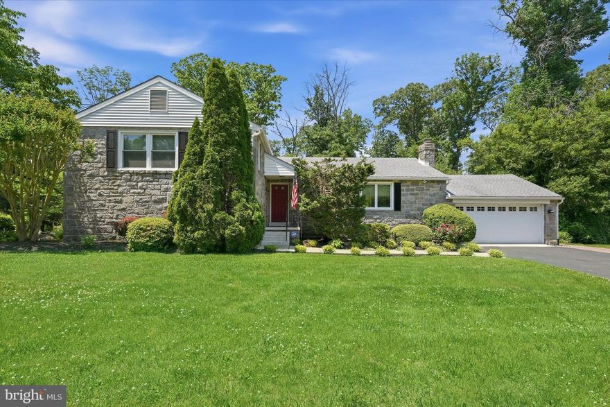 516 Ruxton Drive offers classic North Wilmington charm on a wide, level .52-acre lot surrounded by mature trees. From the curb, this split-level home welcomes you with a red front door, manicured front lawn, and an established setting that feels timeless. Around back, the home opens up beautifully with a glass three-season room, composite deck, paver patio, and a generous yard that backs to mature woods.

Inside, refinished oak hardwood floors run through the living room, dining room, and main-level bedroom wing. The living room features a stone-faced gas fireplace and a wide bank of windows that brings in great natural light. The dining room connects through a cased opening and includes a built-in buffet, adding both charm and function.

The kitchen features full-overlay cherry cabinets, quartz counters, a green and gray glass-tile backsplash, stainless refrigerator, smooth-top range, peninsula seating, and an additional breakfast bar. A glass door leads directly to the back deck, making indoor-outdoor living easy.

The main level includes three bedrooms, all with hardwood floors and ceiling fans. The primary bedroom features a private bath with a tile walk-in shower, frameless glass door, and built-in bench. The hall bath includes a deep soaking tub with a curved rod and coordinating tile finish. A cedar-lined closet off the hallway adds excellent seasonal storage.

The lower level offers a true second living space with a carpeted rec room, recessed lighting, brick wood-burning fireplace with brass doors, and a built-in bar with seating for four. A separate area is currently used as a home gym. This level also includes a half bath, utility room with tankless water heater, and walkout side entrance to the yard.

The three-season room spans the rear of the home with sliders on three sides, indoor-outdoor carpet, and a ceiling fan. Outside, the composite deck stretches across the back of the home and leads to a brick paver patio overlooking the mostly flat lawn and wooded backdrop.

Additional features include a two-car attached garage and a long asphalt driveway with room for additional parking. Located in the Brandywine School District with easy access to I-95, Concord Pike, Marsh Road, downtown Wilmington, the Pennsylvania line, and Philadelphia International Airport.