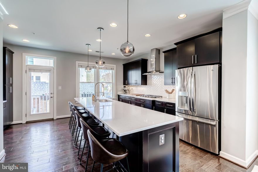 OFFER DEADLINE MONDAY, APRIL 7 AT 2PM. Modern elegance meets urban convenience with an ASSUMABLE  2.25% VA mortgage for eligible VA buyers! Welcome to this stunning end-unit townhome in the heart of South Arlington, where over 2,200 square feet of beautifully curated living space spans four thoughtfully designed levels. From the sleek finishes to the functional layout, every detail in this home has been crafted for comfort and style. Step into the expansive gourmet kitchen—a true showstopper—featuring quartz countertops, a massive center island, custom tile backsplash, wall-mounted oven, and a gas cooktop ready to inspire your inner chef. The open-concept main level boasts hardwood floors throughout, and a walkout deck off the kitchen extends your living space outdoors for effortless entertaining or quiet morning coffee. Upstairs, the primary suite is a private retreat with a custom walk-in closet and a spa-inspired bathroom offering dual vanities and a frameless glass shower. This level also includes a convenient laundry area and a generously sized second bedroom with its own full bath. The top floor is a true gem—ideal for guests, work, or play—with a third bedroom and ensuite bath, plus a versatile loft space perfect for a second living area, home office, or creative studio. From here, step out to your private rooftop terrace and soak in panoramic views—the perfect backdrop for evening gatherings or morning relaxation. The entry-level also includes a flexible fourth bedroom or den, ideal for a home gym, guest suite, or office, and direct access to the two-car garage for added convenience. Located just moments from the energy of Columbia Pike, you’ll enjoy trendy restaurants, coffee shops, fitness studios, and green spaces all within reach. Commuters will love the easy access to I-395, the Pentagon, National Airport, Crystal City, and Ballston—making this a prime location for work and play. Come experience sophisticated city living in one of Arlington’s most vibrant neighborhoods. This is the one you’ve been waiting for!