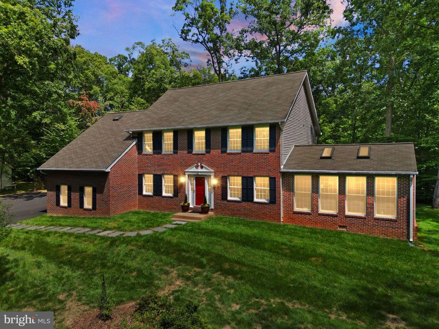 Welcome to this custom-built, spacious 3,800+ SF, brick Colonial estate home on 7.6 acres. The home is perfectly located on the property, offering exceptional seclusion and privacy in one of the most sought-after neighborhoods in Manassas! A long, tree-lined asphalt driveway leads to this elegant residence, creating a grand first impression and a true sense of arrival. Surrounded by mature landscaping and serene wooded views makes this home and property UNIQUE and rarely available. Perfect for those seeking a retreat from the everyday. This 4BR/2.5BA home features 3-LEVELS of living with abundant natural light, open foyer, wide center staircase, and a lengthy list of BRAND NEW and recent updates. SPECIAL FEATURES include: Brand new paint throughout, Brand new upgraded carpet/pad, Brand new trendy light fixtures, Brand new switches and electric outlets. Open concept sparkling Kitchen with peninsula seating and custom-built pantry cabinet. Eat-in kitchen area flows to a large Gathering Room with a wood stove fireplace and walk-out to the exterior brick patio ready for entertaining! Separate formal Living and Dining rooms, Office/Study, and updated Powder Room. Gleaming hardwoods throughout the Main Level. Spectacular Sunroom addition with floor-to-ceiling windows and skylights. Upper Level features a massive Owner’s Suite with a sparkling updated Bathroom, skylight, double sink vanity, custom tile and floor, shower stall and soaking tub, two large walk-in closets and two separate reach-in closets. Additional 3BR’s on Upper Level, generously sized with large walk-in closets and a sparkling Hallway Bathroom with new floor. Lower Level features a large partially finished space built using an upgraded Superior Walls Foundation System, high-strength steel reinforced concrete, R-5 built-in, ready to finish framing and furring strips installed with pre-engineered access for electrical (electrical already installed), and walk-up exterior access. Updated home systems include brand new HVAC (2025), Well Pump (2021), Hardwoods (2021), Refrigerator (2020), Washer/Dryer (2020), Hot Water Heater (2019), Anderson Windows, Water Treatment System, Central Vacuum, Gutter Guard System, Concrete Pad with electric for heated Hot Tub located off the rear patio. Finished, oversized 2-Car Garage with room for storage. Professionally landscaped grounds, freshly mulched, mature hardwood trees. Quick and easy access to Prince William Pkwy & Route 234, close to Routes 28, 95, and 123 commuter lines. Abundant Shopping & Restaurants nearby. Charles Colgan HS pyramid. A-1 Zoning District offers multiple uses for the property as well as Subdivision for Family Land Transfers supporting additional home builds on the property. Exciting Home in an Exciting Location - Welcome Home!