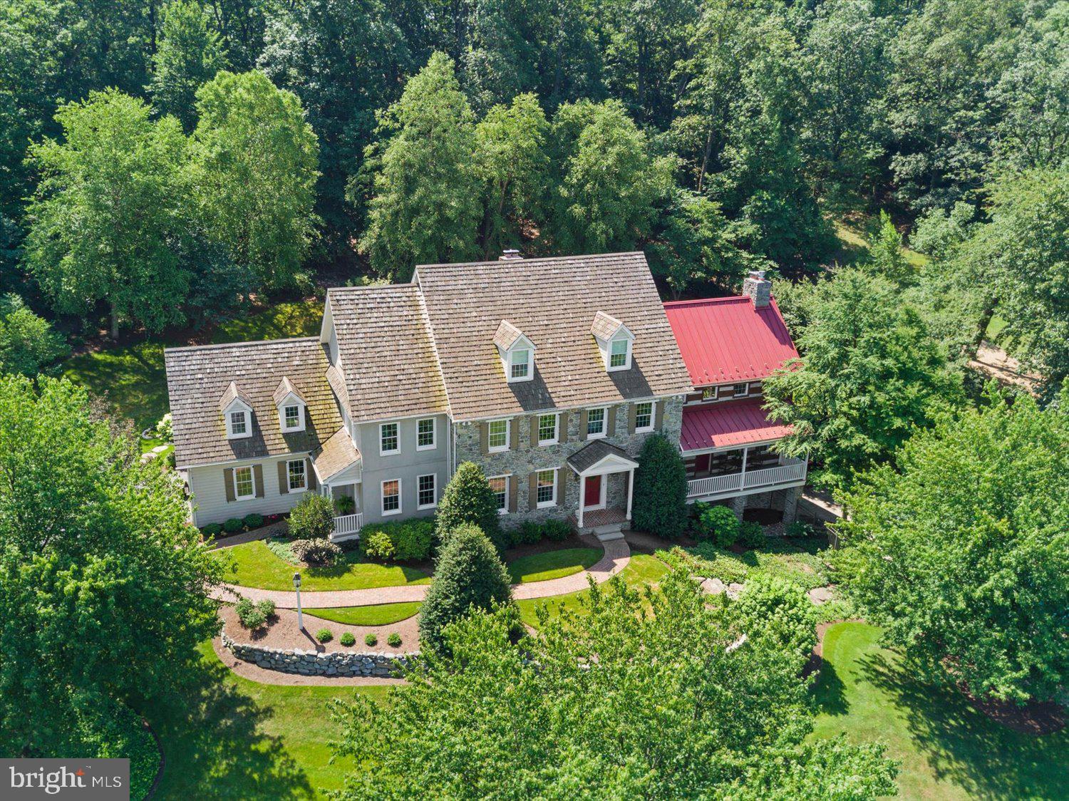With one of the most incredible views you’ll see in all of southeastern Pennsylvania sits this one-of-a-kind Alan Deamer built property you have to see to believe! The introductory drive up the winding driveway takes you from life’s hustle and bustle to a hillside masterpiece of tranquility and serenity - bringing an incredible feeling of peace and relaxation. Preserved through the Farm & Natural Lands Trust of York, this nearly 20 acre estate is nestled high above the adjacent valley for breathtaking views that words just cannot describe. To complement the incredible view, the residence itself will captivate you: with construction completed in 1999, but made to look like a charming 1800s farmhouse on the outside, this home combines the best in modern luxuries and amenities with the character and charm that you see only with older homes. All of the natural stone, both on the interior and exterior of the home as well as the outdoor landscaping, was sourced on-site, enhancing the natural beauty of this estate and keeping it planted within its roots. Inside the residence, you’ll find even more beautiful character - from the reclaimed Lancaster County barn wood flooring on the main level, the magnificent trim work, and the Olde York Homes custom cabinetry throughout the house. Every corner of this home has been thoughtfully designed, including the massive family room with cathedral ceiling, stunning fireplace and mantle, huge picture windows facing the rear courtyard and patio as well as the gorgeous kitchen with plenty of space for entertaining friends and family. Even the Primary Bedroom features cathedral ceilings, beautiful fireplace, and a cozy Juliet balcony - which is a perfect spot to soak in nature and the wildlife that frequently roam this property. This meticulously cared for residence boasts 4 bedrooms (with an easy to convert 5th bedroom over the garage), 4 full/1 half bathrooms, a tastefully finished basement with recreation/bar area and an additional family room with full daylight walkout to the incredible in-ground pool area which overlooks the adjacent meadow and boasts those stunning views of the valley below. There’s no shortage of modern amenities either! With efficient geothermal heating and cooling as well as natural gas, **public water, and public sewer** connected from Druck Valley below, and an expansive sprinkler irrigation system to keep your gardens and lawn lush, you won’t have to compromise comfort while being on a large estate. The list of wonderful things about this home could go on forever, but we’ll summarize with this: if you’re looking for privacy, space, breathtaking views, and serenity with a charming luxury home, all within 30 minutes to downtown Lancaster & York, and an hour drive to BWI Airport - you’ve found it here…you’re home!