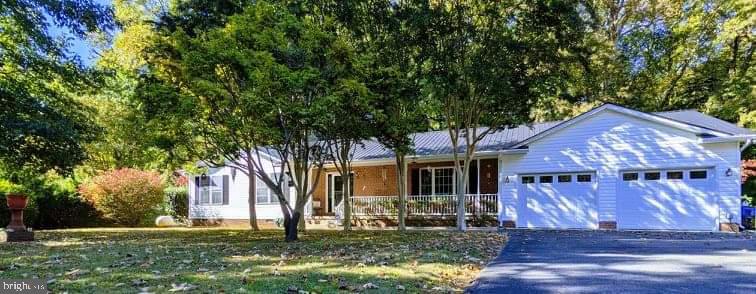 Beautifully maintained 3 bed, 2 bath, oversized 2-car garage sitting on 2+ acres (1/3 wooded), on quiet cul-de-sac in St. Inigoes, MD. 5 minutes from Webster Field and 15 minutes to Patuxent River Naval Air Station. Open concept living room/dining room/kitchen; built-in book shelves on both sides of gas fireplace; Congoleum flooring; carpet in 2 bedrooms; 1 bedroom with laminate flooring; double sinks in guest bathroom; separate laundry room; sliding glass doors lead out to the 12’X28’ screened in back porch; detached 24’X30’ garage on north end of property with electric/water/sewer/cable-ready along with 30amp power outlet. 24’X30’ fenced-in dog cage on concrete slab shaded by surrounding trees; small stream in wooded area behind house with a bridge to other side, as well as shooting range; covered front porch has beautiful Crape Myrtles lining the walkway; plenty of privacy with trees surrounding every side; great neighborhood to live in. 50amp outlet in front of house. Metal Roof installed 2018, Central A/C replaced in 2016, Gas Fireplace, Outdoor Shower. Attached garage (24X30) has shelving, utility sink, propane heater, A/C window unit, large freezer and refrigerator. Schedule your tour today!