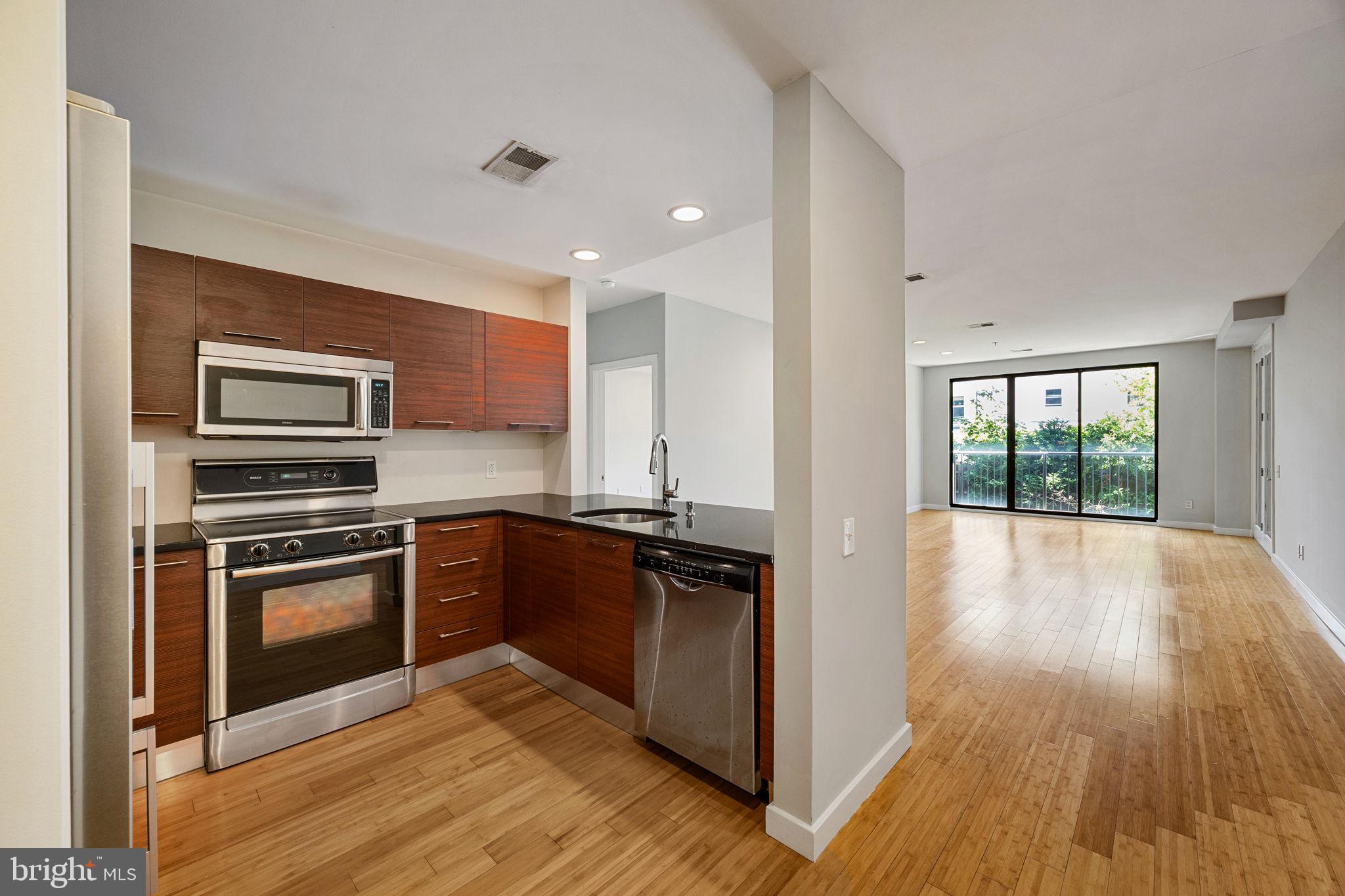 Introducing 934-50 N. 3rd Street #205! Featuring a gated parking garage and located across the street from Liberty Lands Park, this condo impresses immediately with nearly 1400 sq ft, oversized windows, and two split bedrooms. Enter the building through a secure lobby with common mail area and accessible elevator. Roll-down gate secures the garage parking. (Parking space for unit is P23.) Take the elevator or stairs to the second floor where you'll find unit 205. The unit is on the rear side of the building. By not facing the street, you'll enjoy more privacy from your oversized windows as well as from the 90 sqft covered patio. From the common hallway, enter the unit to an updated kitchen at left, open to an oversized living and dining room which separates each of the two bedrooms for privacy. At left, you'll find the primary bedroom with ensuite bathroom and spacious walk-in closets. To the right of the living room, you'll find the common second bathroom as well as a second large bedroom. Both bedrooms feature nearly floor-to-ceiling windows. Convenient to all the neighborhood amenities of Northern Liberties and Fishtown. Just as convenient to Old City, I-95, and Center City Philadelphia. Schedule your private showing today!