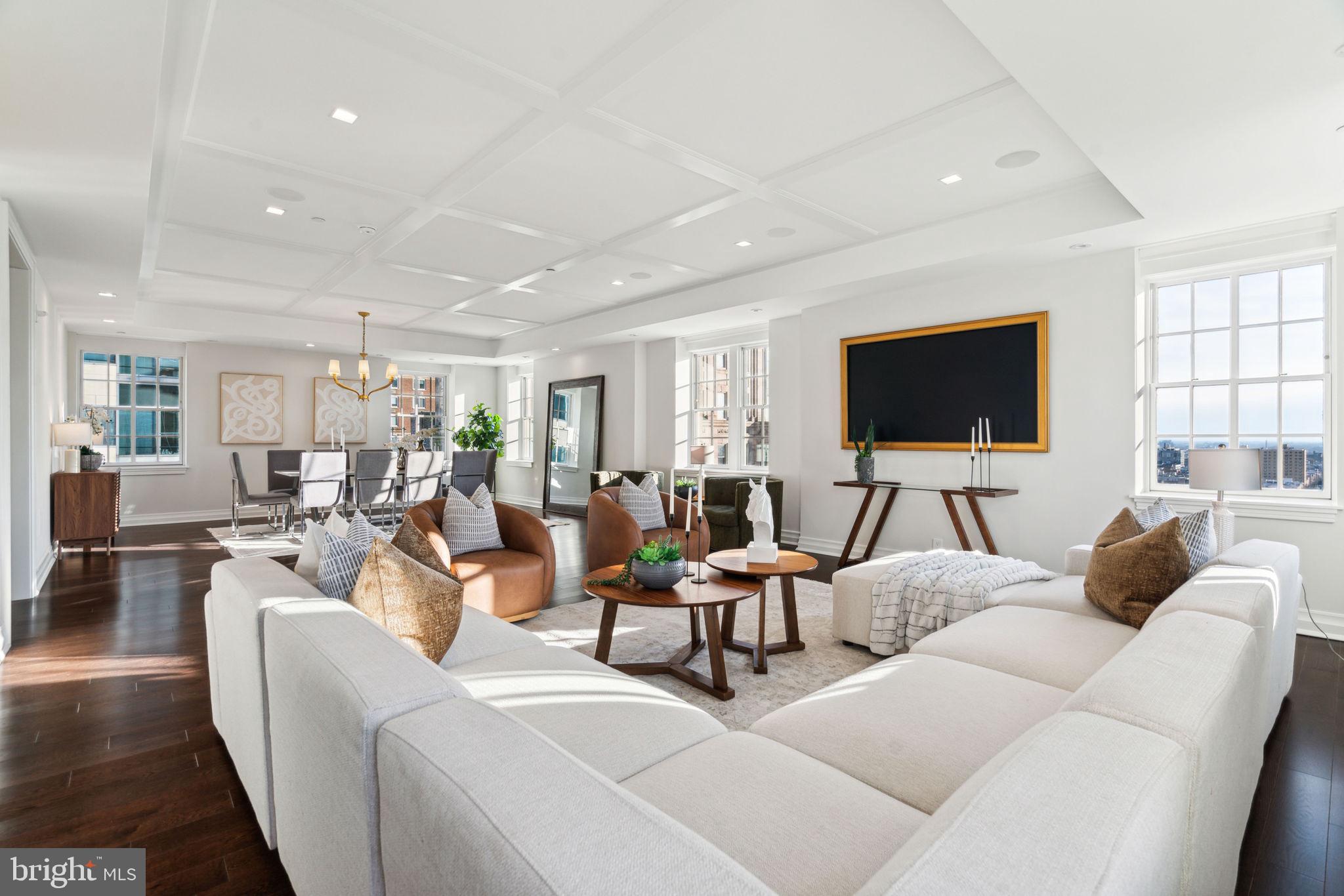 Stunning custom-built full floor residence with luxurious finishes, panoramic city views, and a balcony at The Lanesborough in Center City. This contemporary home includes 4 bedrooms (or 3 plus a private home office), 3.5 bathrooms, Mercier hardwood floors with herringbone inlay, and a plethora of custom appointments and high-end systems. Enter off of the building's secure, fobbed elevator into the custom vestibule with dramatic French doors. Past the entry is the grand center gallery which runs the length of the home. There is a powder room on one side of the hall and laundry closet with LG front load washer and dryer on the other. The private balcony showcasing spectacular city views is also located here. At the end of the center gallery past the bedrooms and office is the open great room with living/dining area and kitchen. An ideal space for both living and entertaining! The expansive living/dining room features 8 windows for ample natural light, a decorative reflective ceiling, surround sound entertainment system, and a 75” Samsung Art TV with gold frame. The open chef’s kitchen features custom Honeybrook cabinetry, Taj Mahal quartzite kitchen counters, and a state of the industry appliance package which includes Miele built-in refrigerator/freezer, Miele professional gas range, Bosch fully integrated dishwasher, Marvel wine & beverage center, Dacor fully integrated wine dispenser & preservation system, Miele built-in coffee center, and Marvel integrated refrigerator drawers. All of the bedrooms feature walk-in designer inspired closets and full ensuite bathrooms. The spacious primary suite boasts large windows, a wood paneled wall feature, a 65” QLED TV, and a large, built-out walk-in closet with shelving and drawers. The gorgeous primary bathroom includes two separate vanities, built-in linen storage, large soaking tub, and an Italian marble oversized walk-in shower with frameless glass entry and accent lighting. Across from the primary bedroom is the home office with French doors and built-ins that can be used as a fourth bedroom. Additional home details include an automated window shade system, an automated lighting system, an “ahead of the curve” computer network, and a music system that includes architectural speakers installed throughout the home that are easily controlled via smart device app. The Lanesborough offers residents the highest level of finish in each space. This elegant boutique building is one of a kind and is sure to please the most discerning purchaser of a Center City high-rise home. Residents enjoy a twenty-four hour doorman and concierge and state-of-the-art fitness center. One 10' x 12' storage unit located in the basement of the building is included.