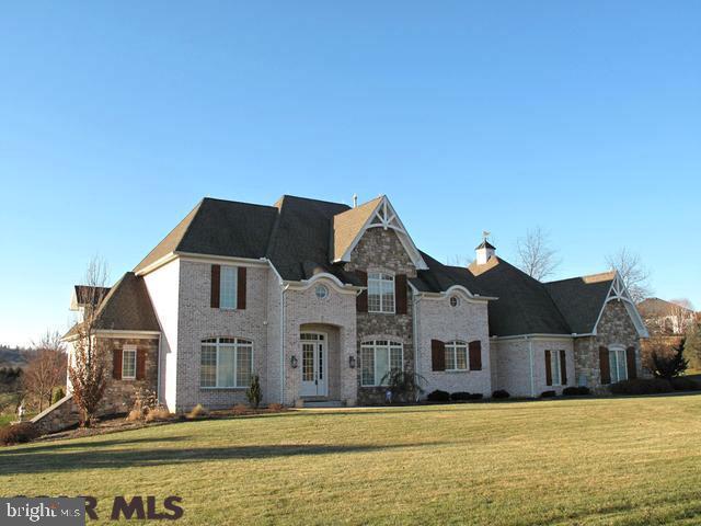Custom built by Sam Homan with great attention to detail and quality throughout. The beautiful exterior is stone and hand thrown brick. Limestone, marble and stone tiled floors compliment the walnut inlaid hardwoods in the main living areas. Light and space are created by the gorgeous entry w/circular staircase & Hubbardton Forge chandelier giving way to 10 ft ceilings on the 1st flr and 9 ft on the 2nd. Custom woodwork, shadow boxing and built ins are found throughout. Fine Closet systems throughout and a handsomely equipped laundry room offers space for hobbies. Enjoy terrific views from the stunning Master Suite. All counters are granite. The 2nd fireplace in the vaulted FR is capped with a copper insert. Enjoy meals or simply relax on the expanded screened porch. The central vac extends to the garage with a 4th bay. The 2nd floor family room/5th bedroom has been freshly re-carpeted. The superior wall basement is walk out with double doors for easy access. A 1 Yr HSA included!