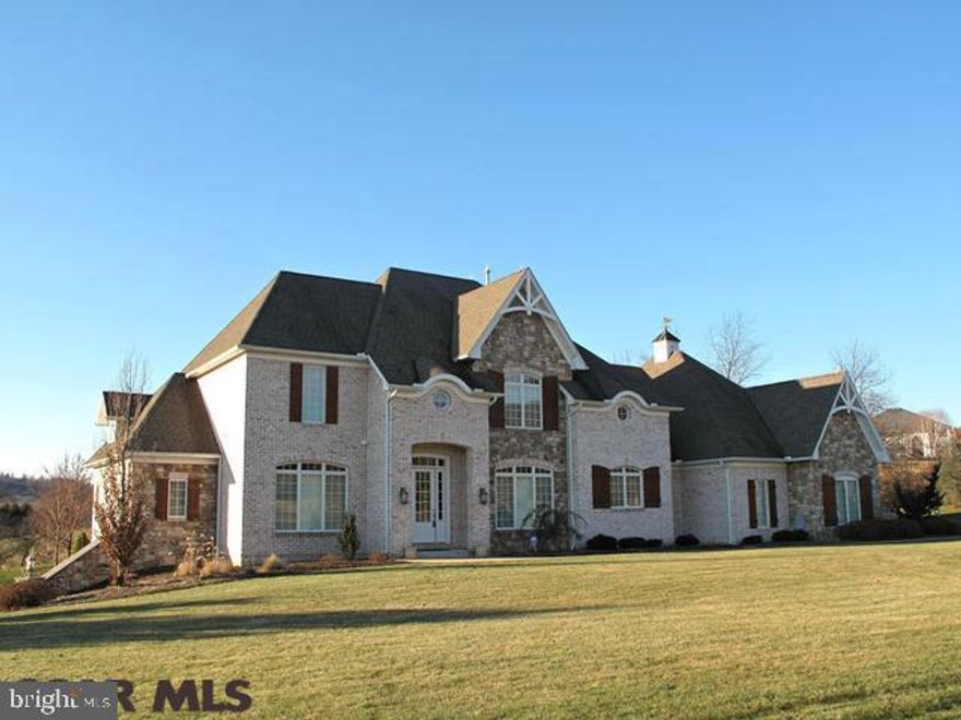 Custom built by Sam Homan with great attention to detail and quality throughout. The beautiful exterior is stone and hand thrown brick. Limestone, marble and stone tiled floors compliment the walnut inlaid hardwoods in the main living areas. Light and space are created by the gorgeous entry w/circular staircase & Hubbardton Forge chandelier giving way to 10 ft ceilings on the 1st flr and 9 ft on the 2nd. Custom woodwork, shadow boxing and built ins are found throughout. Fine Closet systems throughout and a handsomely equipped laundry room offers space for hobbies. Enjoy terrific views from the stunning Master Suite. All counters are granite. The 2nd fireplace in the vaulted FR is capped with a copper insert. Enjoy meals or simply relax on the expanded screened porch. The central vac extends to the garage with a 4th bay. The 2nd floor family room/5th bedroom has been freshly re-carpeted. The superior wall basement is walk out with double doors for easy access. A 1 Yr HSA included!