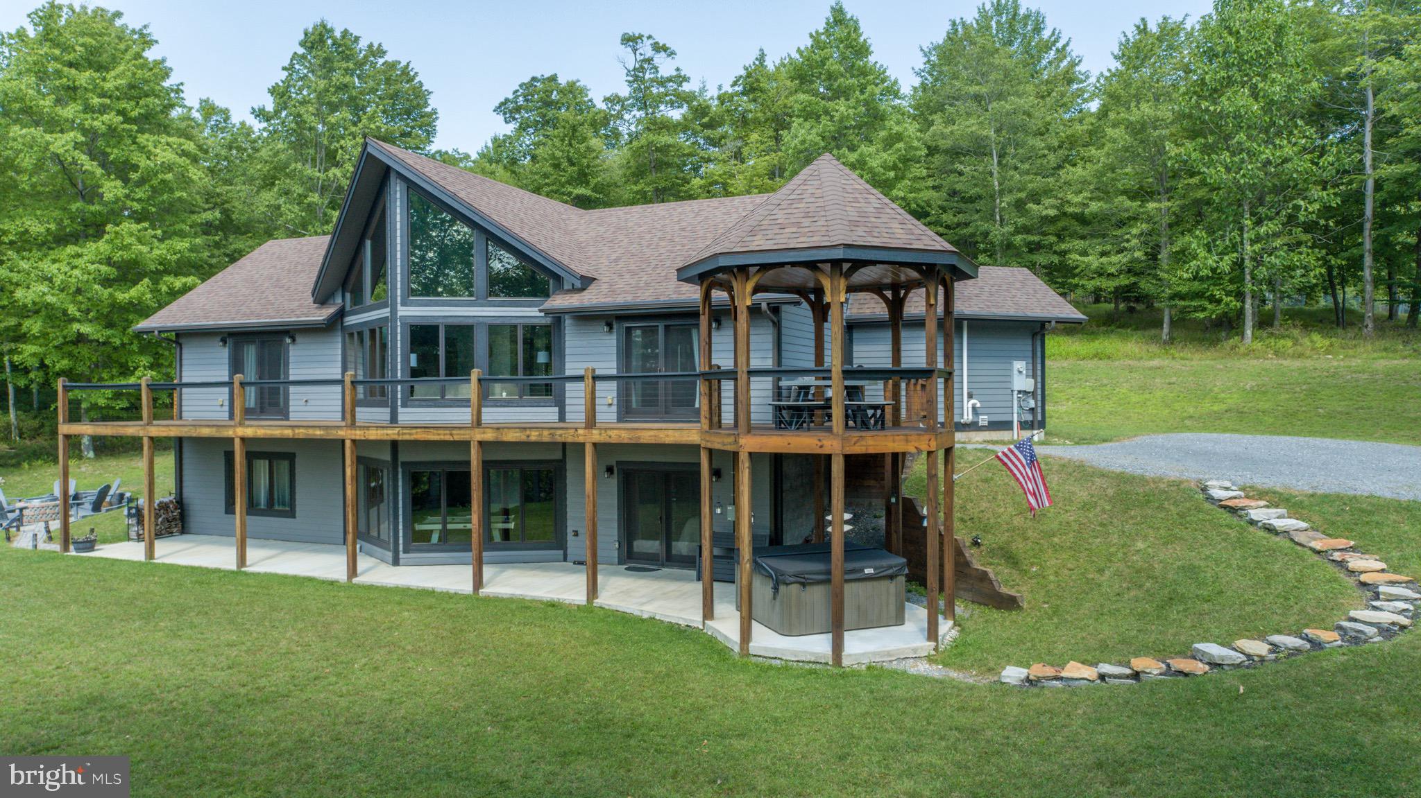 722 Windings Estates offers one of the most elegant mountain homes Deep Creek Lake has to offer. This 4BR/2.5BA home spans over 2 levels with over 3000 square feet of living space and a premium, 1 acre lot. Enjoy the evening sunsets looking over the lake from the expansive porch with western exposure or a warm cup of coffee on the covered back porch. Entertain guests in the premium main level kitchen with 6 burner gas stove and plenty of space for guests. The main level includes a main level bedroom suite with its own custom bathroom, soaking tub sand heated floors for those chilly mornings. The lower level offers a second living room with 3 bedrooms and 1.5 bathrooms. The lower level walks out to an expansive patio with hot tub and fire pit just steps away. Whole house generator conveys with property! Looking for your ultimate mountain retreat? Call today to schedule a tour at this fantastic property!