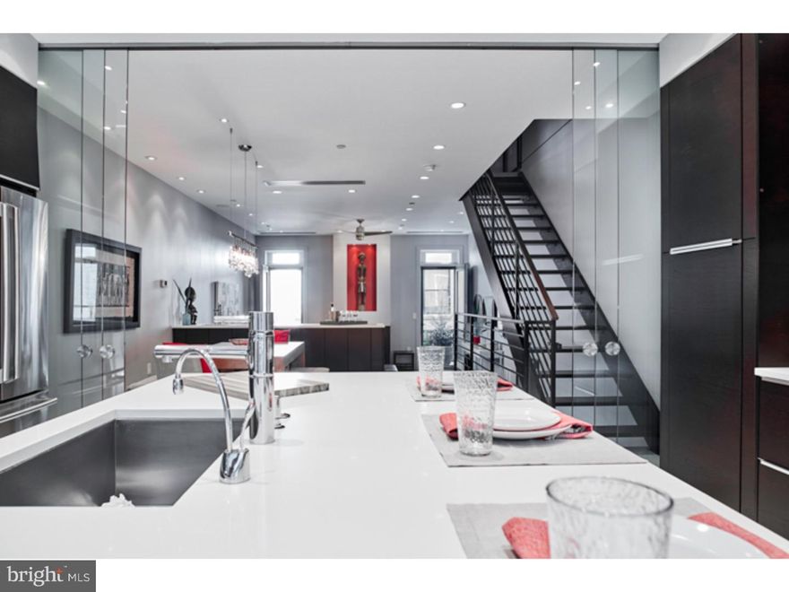 Set your sights on this extraordinary custom-built modern luxurious residence in The Greenfield School Catchment with Garage parking and approximately 5 years remaining on the Tax Abatement. This home is pure perfection. Crisp white tile flooring can be heated to your desire throughout the home. Built-in Speaker System and surround sound, designer lighting fixtures with ambient controls to customize your environment, dramatic entry foyer, floating staircases, soaring ceilings. Three bedrooms, four full bathrooms with tasteful selections. The First floor study with gas fireplace overlooks one of three outdoors spaces and is just the place to relax and be at peace. The second floor of this home was thoughtfully designed for both a quiet evening at home or dynamite gathering with friends. Take in the expansive living room with a floating gas fireplace, hardwood flooring & balcony that stretches across the rear of the home. A gas lined chef's grill completes the balcony. Perched above the living room, the dining room offers a wet bar and custom storage & seamlessly flows into the kitchen at the front of the residence, overlooking Bainbridge Street. Stainless steel appliances include a Thermador induction cook top, Double Oven by Viking, an abundance of cabinetry & an oversized island. Insulate your family and friends from dinner preparations by enclosing the kitchen with the custom glass sliders. Two bedrooms with walk-in closets complemented by well-appointed wardrobes that anchor the two spa-inspired Jack & Jill baths complete with custom tiling, heated flooring, steam shower and choice fixtures. Enjoy southern views as you retire to the Master suite. Master bath offers floating dual vanities, beautifully appointed tiling, oversized skylight and heated flooring. Hard to miss is the oversized jetted tub. Built-in storage and wet bar provides added convenience as you enjoy skyline views and evening sunsets on your top floor balcony. Finished basement offers additional living space, a large storage area and thoughtfully compartmentalized mechanical rooms. On-Demand water heater and high efficiency systems were selected to increase the comfort and enjoyment of this exquisite residence. A convenient location surrounded by multi-million dollar real estate and is within steps of first-rate restaurants, cafes and shops. A quick stroll to Rittenhouse Square, Dog Parks and more.