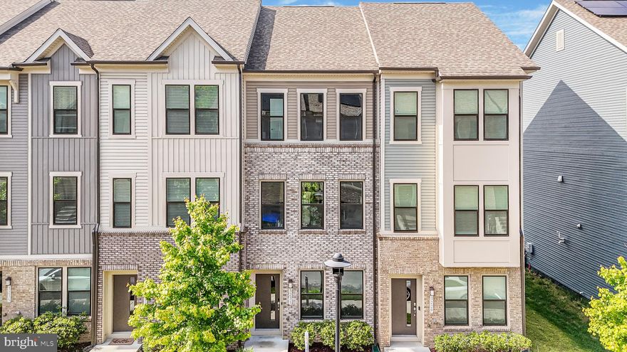 Nestled within the highly sought-after, amenity-rich community of Watershed, welcome to 3231 Watershed Boulevard — a sophisticated luxury townhome where elevated design, thoughtful upgrades, and effortless convenience converge. Showcasing timeless curb appeal with a striking brick water table, refined vinyl siding, rear-loading one-car garage, and private driveway, this impeccably maintained interior residence immediately impresses from the moment you arrive. Step inside to sun-drenched interiors adorned with fresh designer paint, luxury vinyl plank flooring, and rich white oak hardwood staircases that create warmth and continuity throughout. The welcoming foyer introduces a private entry-level bedroom suite complete with a ceiling fan, full bath featuring quartz countertops, ceramic tile flooring, and a tub/shower combination — ideal for guests, multigenerational living, or a private office retreat. Access to the garage reveals premium upgrades including an EV charger, reverse osmosis system, water softener, and a 50-gallon electric water heater. Ascend to the stunning main living level where expansive open-concept living unfolds beneath recessed lighting and abundant natural sunlight. The gourmet kitchen is a true showpiece, beautifully appointed with 42-inch snow-white cabinetry, Frost White quartz countertops, stainless steel appliances, pendant lighting, spacious pantry storage, and an oversized breakfast nook with direct access to a private TRX deck overlooking lush community greenery, gathering spaces, and outdoor recreation areas. The adjoining family room offers a seamless entertaining experience with airy sunlit interiors, recessed lighting, and elevated finishes throughout. Upstairs, retreat to the luxurious primary suite featuring dual spacious closets, recessed lighting, and a spa-inspired ensuite bath adorned with double vanities, Frost White quartz countertops, ceramic tile flooring, and a walk-in shower designed with timeless elegance. An additional upper-level bedroom continues the home’s upscale aesthetic with luxury vinyl plank flooring, recessed lighting, abundant natural light, ceiling fan, walk-in closet, and a private ensuite bath with quartz countertops and ceramic tile finishes. Residents of Watershed enjoy resort-style amenities including a community pool, clubhouse, fitness center, playgrounds, walking trails, green spaces, dog park, and gathering areas designed for an active and connected lifestyle. Perfectly positioned moments from commuter routes 295, Route 100, and Route 32, this exceptional residence offers seamless access to Baltimore, Washington D.C., Fort Meade, NSA, and BWI Airport while being surrounded by premier shopping, dining, and everyday conveniences including Target, Walmart, Panera Bread, Starbucks, and countless nearby restaurants and retail destinations. Luxury, location, and lifestyle seamlessly unite in this extraordinary offering.