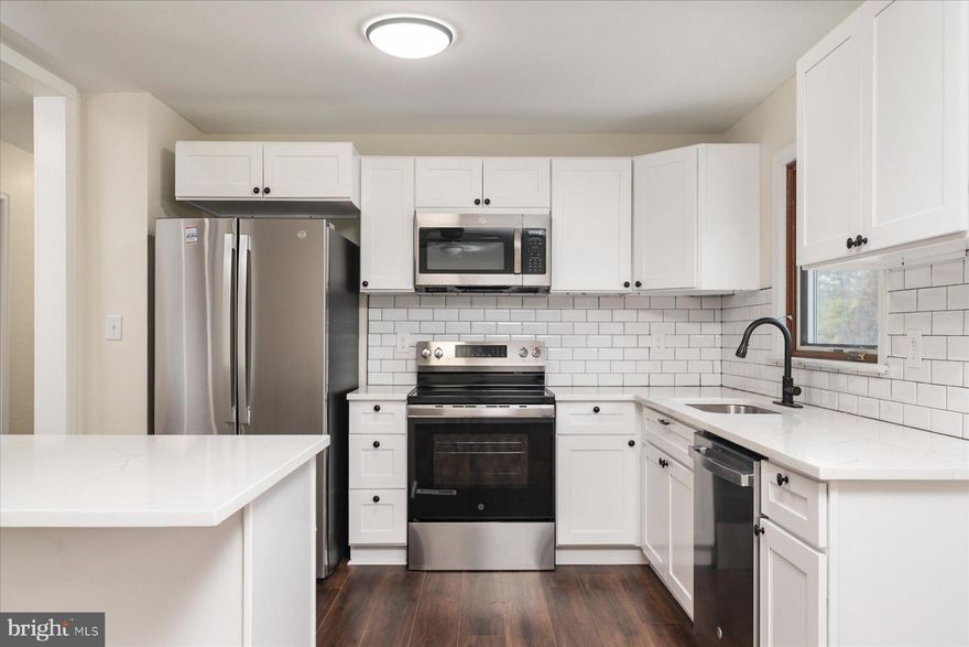 Welcome to 100 Carroll Drive, a fully remodeled four-bedroom, two-bath split foyer in the desirable and sought-after waterfront community of Hillsmere Shores in Annapolis. The upper level features a completely renovated open-concept layout with a stunning kitchen showcasing new cabinetry, new appliances, countertops, and luxury vinyl flooring throughout, flowing seamlessly into the dining and living areas—perfect for everyday living and entertaining. Just off the living room, enjoy an enclosed deck that adds extra flexible space and a great place to relax or entertain. This level also includes three spacious bedrooms and an updated full bathroom. Downstairs, the home continues to impress with tiled flooring throughout, heated floors, and a large primary suite with a private full bathroom, plus walkout access to an enclosed patio featuring a heated exercise pool or hot tub. Outside, the property offers a large cleared lot with beautiful landscaping, an irrigation system, and a shed for additional storage. Hillsmere Shores is known for its exceptional community amenities including a marina, multiple boat ramps and kayak launches, a beach, playground, and access to Quiet Waters Park, with the Key School conveniently located right across the street. An electric vehicle charger is also included, adding even more value and convenience—this move-in ready home is a rare opportunity to enjoy a renovated property and an unmatched Annapolis lifestyle.