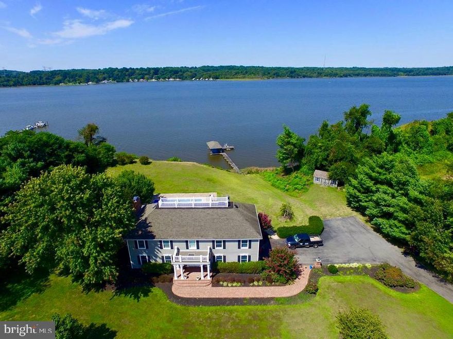 Stately colonial with a coastal flair!  Situated on 4.63 level acres, this property is mostly cleared and buffered on both sides by  tree lines offering plenty of privacy.   Enjoy unparalleled views of the sun setting over the Patuxent River from your back yard, large patio,  or four-season  sunroom.  Built in 1987, the home was  updated in 2006 with  a complete  kitchen remodel including granite countertops, semi-custom cabinetry, stainless steel farm sink,  professional 6 burner gas range , high-end appliances, hardwood flooring throughout , new roof  on the covered boat slip and brick paver pool surround .  A 2010 remodel included  wide plank fiber-cement siding, new shutters and garage doors,  Andersen replacement windows throughout, designer master bath and hall bath remodels,  new front porch, wide brick walkway and lighted entry pillars.  The barn/garage exterior was also upgraded with new siding ,doors, windows and a metal roof.   The upper level three bedrooms, a laundry room and  a 22 x 30 bonus/rec room with new laminate plank flooring,  and a permanent staircase to the floored attic for additional storage and possible future living space.   The master bedroom, rec room, family room and sunroom offer stunning views!!    Enjoy the inground pool with new liner, and use the  pool house for accessory storage. With 269 feet of river frontage, watersport enthusiasts will  appreciate the pier with a covered slip and boat lift as well as two  jet ski lifts.   The 24 x 36 barn/garage on the property provides extra storage and includes a horse stall.   Own your piece of the country within commuting distance to Washington D.C., Annapolis and NAVAIR at Patuxent River.  Don't miss out on this one!!