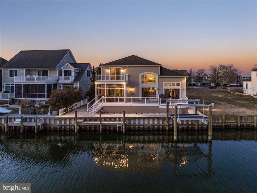 Rarely does a single-family home become available in the highly sought-after community of Heron Harbour Isle in Ocean City, Maryland. This is your opportunity to own a stunning waterfront residence featuring over $458,000 in upgrades and improvements, sold fully furnished and ready for immediate enjoyment. This exquisite, one-of-a-kind custom waterfront estate offers a truly elevated coastal lifestyle with breathtaking views. Exceptional craftsmanship and meticulous attention to detail are evident throughout, making this home ideal for the sophisticated buyer seeking custom finishes, efficiency, and timeless elegance. Situated on one of the largest lots in the community—a 9,549 sq. ft. lot—the property boasts extensive hardscaping and lush landscaping.  As you arrive via the paver driveway, you’ll immediately appreciate the home’s luxury curb appeal. Step inside to be welcomed by abundant natural light and desirable southern exposure, all overlooking the water. The family room features soaring double ceilings, a gas fireplace for year-round enjoyment, and a wall of windows showcasing spectacular waterfront, skyline, and bird sanctuary views—an inviting space perfect for entertaining family and friends. The chef’s kitchen is a dream, complete with double convection ovens, an abundance of custom cabinetry, and a spacious breakfast bar. It flows seamlessly into the eat-in breakfast area and formal dining room, ideal for hosting large gatherings. The first-floor primary suite overlooks the water and offers direct access to a large, screened porch—perfect for enjoying your morning coffee. The fully remodeled en-suite bath features a tiled shower, dual vanities, new flooring, and custom cabinetry. The first floor also includes a laundry room and convenient half bath.  The second floor offers three additional bedrooms, including one that overlooks the water and features a private balcony—a retreat where guests are treated like royalty. A fully remodeled bathroom serves this level, making it ideal for hosting family and friends in comfort and style. Outdoor living is exceptional, with multiple decks redone with composite decking and sleek clear railings to maximize the breathtaking views. A screened porch provides the perfect setting for outdoor dining and relaxing in the coastal breeze. This home has been thoughtfully upgraded with no detail overlooked. The bulkhead was replaced in 2021, and a new boat lift was added in 2022, enhancing both value and waterfront enjoyment. The screened porch was redone by Mill Creek Builders and rescreened in 2024. The crawlspace has been fully encapsulated by Dry Zone, and the home features a whole-house entertainment system. Custom curtains and blinds by Designing Windows add a refined finishing touch throughout. The extensive upgrade list truly goes on and on—this is a rare offering that combines luxury, functionality, and an unbeatable waterfront lifestyle. Heron Harbour Isle is amenity rich with two outdoor pools, an indoor pool, a kiddie pool, fitness center, social room, sauna, locker room, two Har-Tru tennis courts, sidewalks and piers. Enjoy your boat, fishing, crabbing, kayaking and paddle boarding all directly out your back door.
