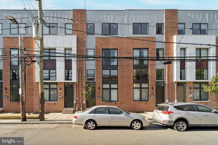 Welcome to 322 Fairmount Avenue, a spacious 3 bedroom, 3.5 bathroom home in the heart of Northern Liberties. Step inside to an impressive living area with soaring two story ceilings and dramatic windows that fill the space with natural light. The open layout flows into a modern kitchen with quartz countertops, custom cabinetry, stainless steel appliances, and a large dining area. Just off the kitchen you will find a private deck, perfect for everyday relaxation or entertaining. Upstairs, two well-sized bedrooms each offer generous closet space and their own full bathrooms. The entire next level is dedicated to the primary suite, featuring a large bedroom, walk-in closets, and a private bath with double vanity, glass-enclosed shower, and stylish finishes. On the top level, an oversized roof deck provides plenty of room for gatherings and offers sweeping skyline views. Additional features include garage parking, a convenient powder room on the first level, full-size washer and dryer, hardwood floors throughout, recessed lighting and excellent ceiling heights Set near Liberty Lands Park and some of the best restaurants and cafes in the neighborhood, this home combines comfort, convenience, and location in one of Philadelphia’s most vibrant communities. Come see it for yourself!