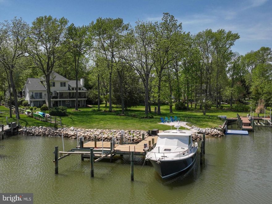 This stunning property offers the best of both worlds with expansive, wide-open views of Glebe Bay all the way to the South River and a protected lagoon location. Views from the home and sprawling lawn are spectacular! The well-maintained, quality-constructed home has a timeless, open floorplan.  Enter into a spacious foyer flanked by living and dining spaces. Ascend the stairs, to the first landing, open to the large family room with a vaulted ceiling where a wall of windows provides incredible views one will never tire of.  Easily stay in the mix with other household members while preparing meals with the open kitchen and family room layout. Just off the kitchen is a 28' wide, screened in porch, offering an incredible outdoor entertainment space. The primary suite, located on the main level is generously sized with fabulous water views, gas fireplace, a tastefully renovated private ensuite bathroom and two walk-in closets. Sliding doors in the primary bedroom lead to a deck spanning the distance to the screened porch, perfect for taking in the morning sun over the lagoon.  The upper level has three bedrooms and another updated full bathroom. The lower level is fully finished with an open kitchen living space, two-sided fireplace for enjoyment from the living room or bedroom, a full bath with jetted tub, sliding doors to a large paver patio, a separate exercise space with separate walkout entrance. The configuration is perfect as a separate living space, and could also serve as additional entertainment space with room to spread out at large gatherings.  Many updates have been done including roof (2020), HVAC (2018), upgraded water treatment system, stamped asphalt driveway. Approximately 83' of rip-rapped water frontage with a paddleboard and kayak launch. Private pier with average 4.5' depth in the slips, 10k lb boat lift, separate jet ski lift, large boat slip, and a deeded mooring ball in Glebe Bay. This unique waterfront location is perfect for enjoying every aspect of the waterfront lifestlye in the best boating destination the east coast has to offer.