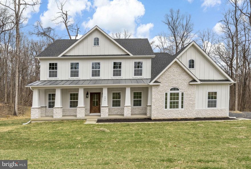 Timeless Colonial Charm Meets Modern Comfort—Move-In Ready!

Discover a perfect fusion of classic elegance and contemporary luxury in this newly constructed Colonial home, nestled on 3.94 acres of lush, wooded serenity. Offering unmatched privacy and peaceful surroundings, this refined retreat delivers the comfort of modern living without sacrificing timeless charm.

A beautifully paved driveway sets a sophisticated tone, leading to a striking Colonial façade enhanced by a full-width front porch with Craftsman-style columns—a perfect blend of traditional architecture and inviting curb appeal. Whether you're sipping morning coffee or unwinding in the evening, this charming porch offers a warm welcome and a peaceful place to relax.

Step inside to an open-concept floor plan bathed in natural light, where there are expansive windows that frame picturesque woodland views.

At the heart of the home lies a chef-inspired kitchen—complete with quartz countertops, custom cabinetry, stainless steel appliances, and a spacious center island perfect for casual dining or lively gatherings. The adjoining formal dining area and cozy family room with a fireplace create a warm and welcoming ambiance for both entertaining and everyday living.

The main-level primary suite is your personal sanctuary, featuring a spa-like en-suite bath with a soaking tub, walk-in shower, dual vanity, and generous walk-in closet. A versatile bonus room on this level is ideal for a home office, library, or playroom—tailored to your lifestyle needs.

Upstairs, three spacious bedrooms offer comfort and privacy, each with easy access to private or semi-private bathrooms—perfect for family members or guests.

Step outside onto the expansive composite deck to take in the beauty of your wooded oasis. Whether you’re hiking your private trails, hosting al fresco dinners, or simply enjoying the sounds of nature, this nearly 4-acre property invites endless outdoor enjoyment.

The fully finished garage is designed with convenience in mind, featuring two automatic openers, a pedestrian door, painted walls, finished flooring, and ample storage space.

In addition to its peaceful, secluded setting, this home is ideally located near a wealth of historical and recreational attractions. Explore nearby Civil War battlefields, hike or bike along scenic trails, or take a short drive to the vibrant towns of Harpers Ferry, Charles Town, Leesburg, and Winchester. Whether you're a history enthusiast, outdoor adventurer, or just looking to enjoy charming local destinations, you'll find something for everyone just minutes away.  

Though tucked away in nature, you’re just a short drive from top-rated schools, shopping, and everyday amenities. Whether you're looking for your forever home or a luxurious weekend escape, this Colonial masterpiece offers the best of all worlds—timeless style, modern comfort, and natural beauty.

This exceptional home is ready for you—schedule your private tour today!