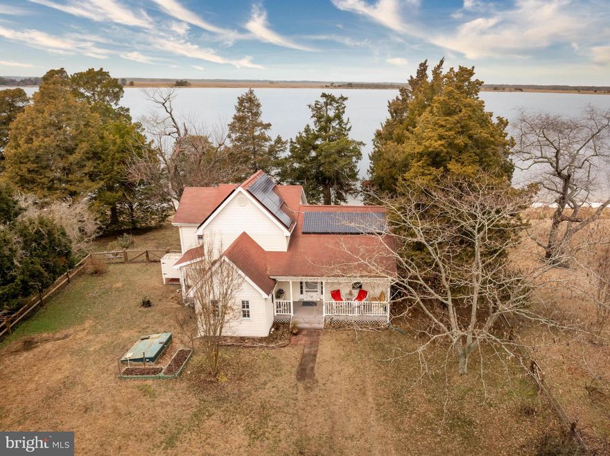 Welcome to easy living on the shores of the Wicomico River, where life moves a little slower and the sunsets seem to last a little longer. “The Anchorage,” originally built in 1870 and lovingly expanded with two additions over the years, is a waterfront home full of character, comfort, and the kind of charm you just can’t recreate.
As soon as you enter, your eyes are naturally drawn to the water. The spacious living room is lined with large windows that beautifully frame the peaceful river, keeping those calming views front and center.  The main level also offers a comfortable dining area perfect for gathering, a welcoming kitchen, first-floor bedroom, full bath, laundry space, and a generous pantry with plenty of storage for everyday living. Out back, you’ll find what just might become your favorite spot in the whole house — the three-season room overlooking the water. Imagine early mornings with a hot cup of coffee as the river comes to life, lazy afternoons with a good book and a breeze drifting through, and evenings with a glass of wine as the sky turns soft shades of gold and pink. Outside, mature trees create a soft, shaded setting that feels private and relaxed, including blooming mimosa and crape myrtles that add color and charm throughout the warmer months.It’s peaceful, private, and simply unmatched. Back inside, the upstairs features another full bath, a flexible space perfect for a walk-in closet or cozy nook, and two attached bedrooms that feel tucked away and restful. Easy access to the walk-in attic makes storing keepsakes and seasonal décor a breeze. Outside, sandy beach frontage invites you to kick off your shoes and enjoy the shoreline, while a fenced portion of the yard adds an extra layer of privacy and peace of mind — perfect for little ones or four-legged friends to roam safely. There’s an outdoor shower for rinsing off after a swim, leased Tesla solar panels for added efficiency, a new roof on the three-season room, and a spacious detached building ready to house your fishing gear, lawn equipment, and all the toys that come with waterfront living. Located just minutes from the Mount Vernon Harbor & Boat Ramp, you’re ideally positioned for days spent fishing, crabbing, and embracing the laid-back lifestyle of Somerset County — with direct boating access to the beautiful Chesapeake Bay right from the Wicomico River, opening the door to endless waterfront adventures. And when you’re ready for a change of scenery, you’re only about an hour’s drive to the beaches of Ocean City, the wild natural beauty of Assateague Island, and the charming coastal town of Chincoteague. Whether you’re looking for a full-time home or a weekend escape, this is the kind of place where memories are made the old-fashioned way — barefoot summers, river breezes, and time spent with the people who matter most. Come settle in and make it yours. *Please note 3rd party websites may reflect incorrect property tax amount - taxes are around $3,207.*