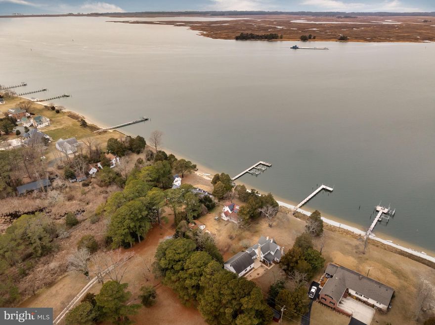 Welcome to easy living on the shores of the Wicomico River, where life moves a little slower and the sunsets seem to last a little longer. “The Anchorage,” originally built in 1870 and lovingly expanded with two additions over the years, is a waterfront home full of character, comfort, and the kind of charm you just can’t recreate.
As soon as you enter, your eyes are naturally drawn to the water. The spacious living room is lined with large windows that beautifully frame the peaceful river, keeping those calming views front and center.  The main level also offers a comfortable dining area perfect for gathering, a welcoming kitchen, first-floor bedroom, full bath, laundry space, and a generous pantry with plenty of storage for everyday living. Out back, you’ll find what just might become your favorite spot in the whole house — the three-season room overlooking the water. Imagine early mornings with a hot cup of coffee as the river comes to life, lazy afternoons with a good book and a breeze drifting through, and evenings with a glass of wine as the sky turns soft shades of gold and pink. Outside, mature trees create a soft, shaded setting that feels private and relaxed, including blooming mimosa and crape myrtles that add color and charm throughout the warmer months.It’s peaceful, private, and simply unmatched. Back inside, the upstairs features another full bath, a flexible space perfect for a walk-in closet or cozy nook, and two attached bedrooms that feel tucked away and restful. Easy access to the walk-in attic makes storing keepsakes and seasonal décor a breeze. Outside, sandy beach frontage invites you to kick off your shoes and enjoy the shoreline, while a fenced portion of the yard adds an extra layer of privacy and peace of mind — perfect for little ones or four-legged friends to roam safely. There’s an outdoor shower for rinsing off after a swim, leased Tesla solar panels for added efficiency, a new roof on the three-season room, and a spacious detached building ready to house your fishing gear, lawn equipment, and all the toys that come with waterfront living. Located just minutes from the Mount Vernon Harbor & Boat Ramp, you’re ideally positioned for days spent fishing, crabbing, and embracing the laid-back lifestyle of Somerset County — with direct boating access to the beautiful Chesapeake Bay right from the Wicomico River, opening the door to endless waterfront adventures. And when you’re ready for a change of scenery, you’re only about an hour’s drive to the beaches of Ocean City, the wild natural beauty of Assateague Island, and the charming coastal town of Chincoteague. Whether you’re looking for a full-time home or a weekend escape, this is the kind of place where memories are made the old-fashioned way — barefoot summers, river breezes, and time spent with the people who matter most. Come settle in and make it yours. *Please note 3rd party websites may reflect incorrect property tax amount - taxes are around $3,207.*